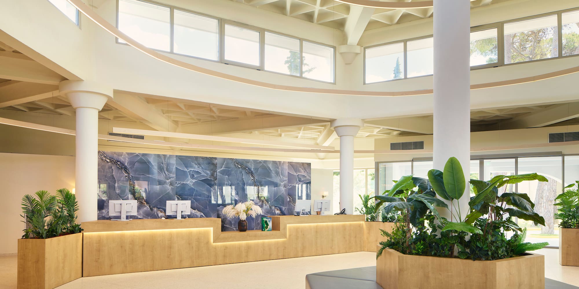 a lobby with a large stone wall and plants