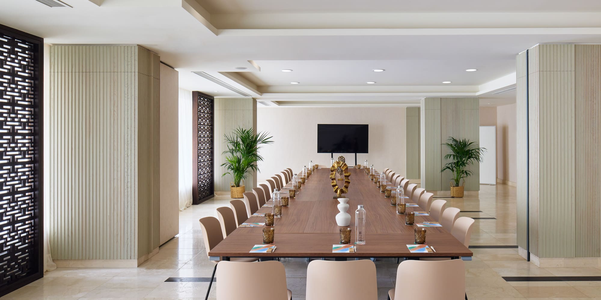 a long table with chairs and a television in the middle