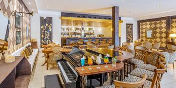 a bar with a piano and chairs