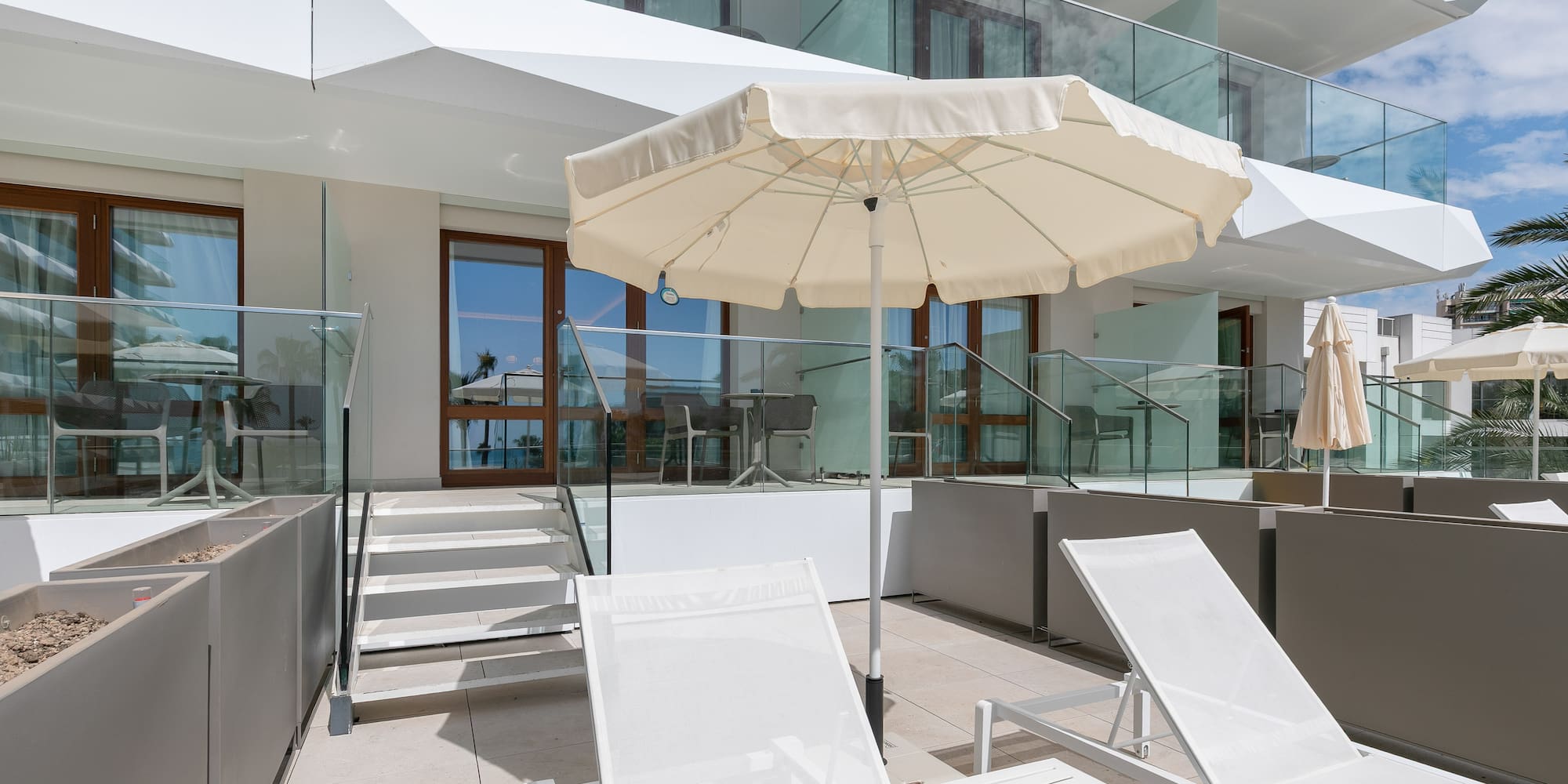 a white umbrella and chairs on a patio