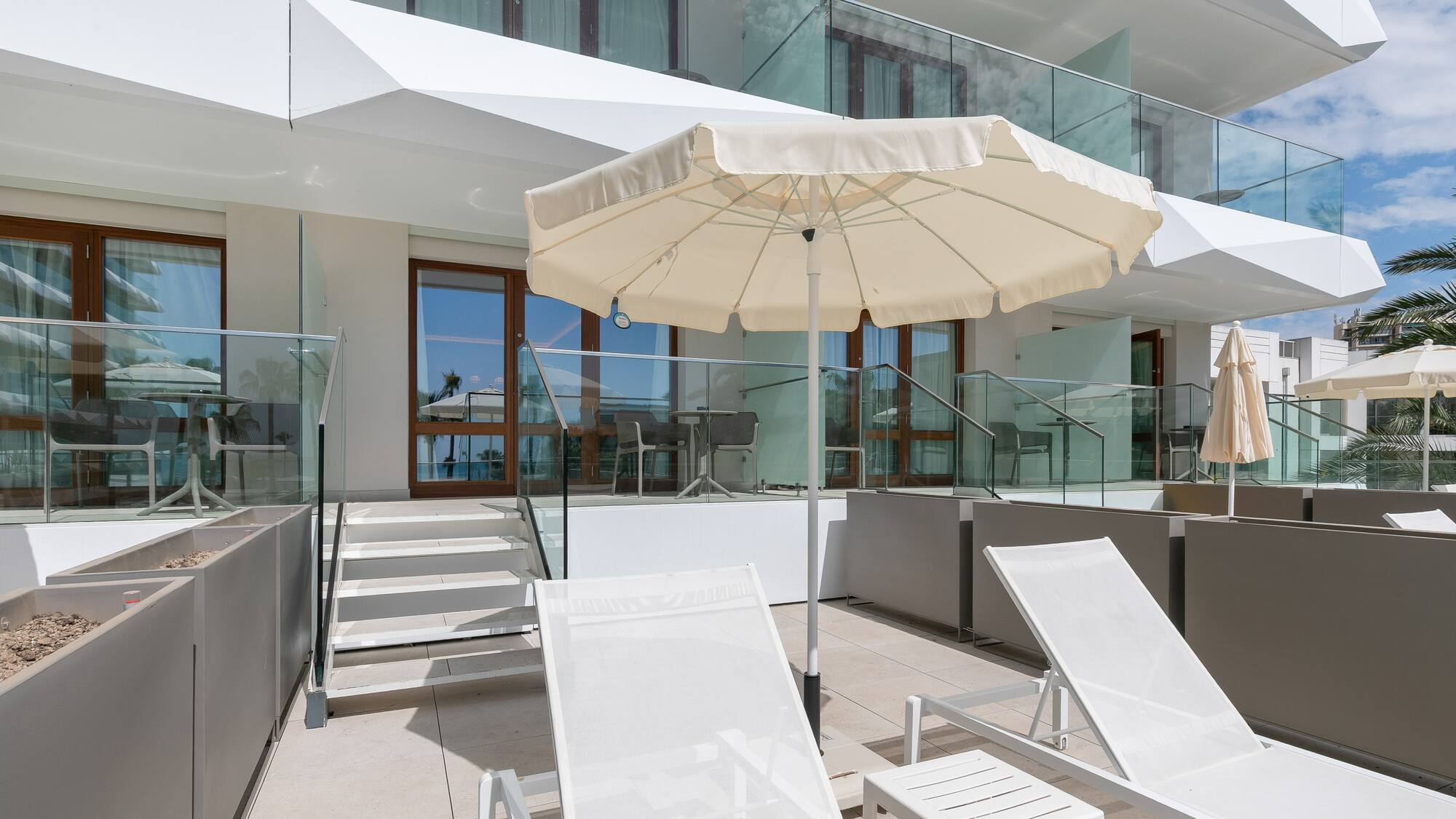 a white umbrella and chairs on a patio