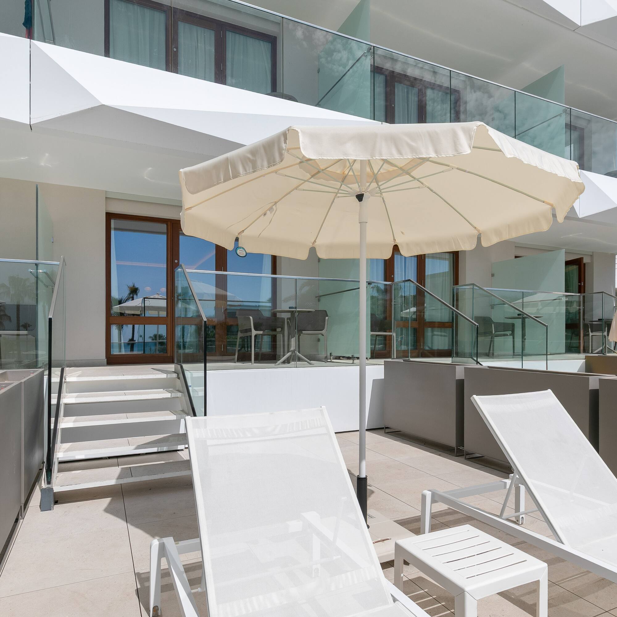 a white umbrella and chairs on a patio