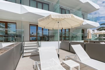 a white umbrella and chairs on a patio