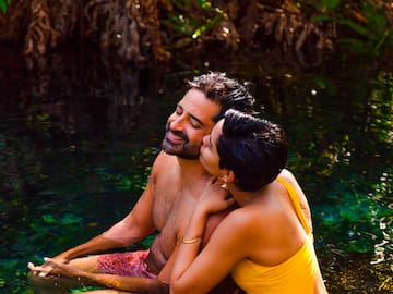 a man and woman kissing in water
