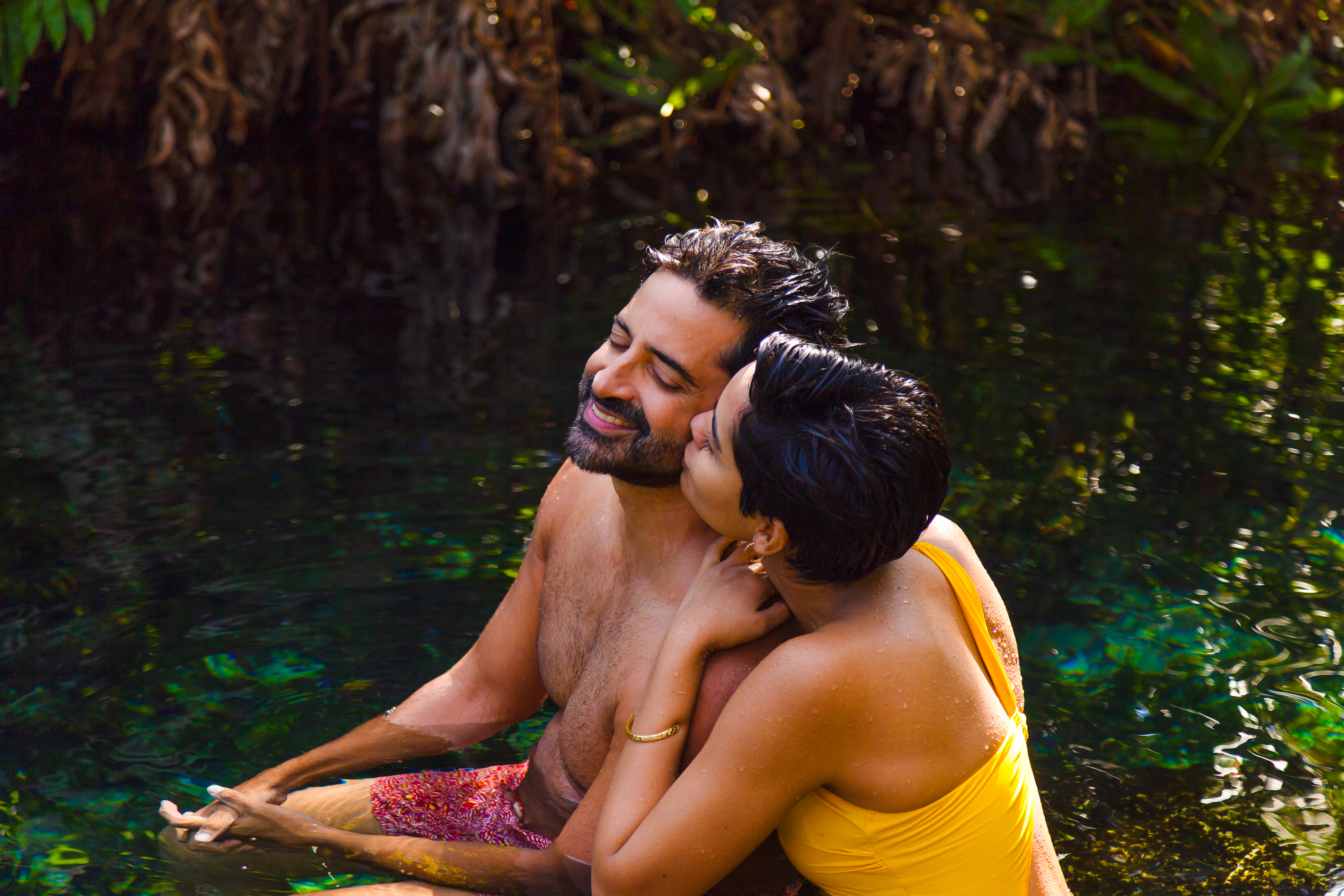 a man and woman kissing in water