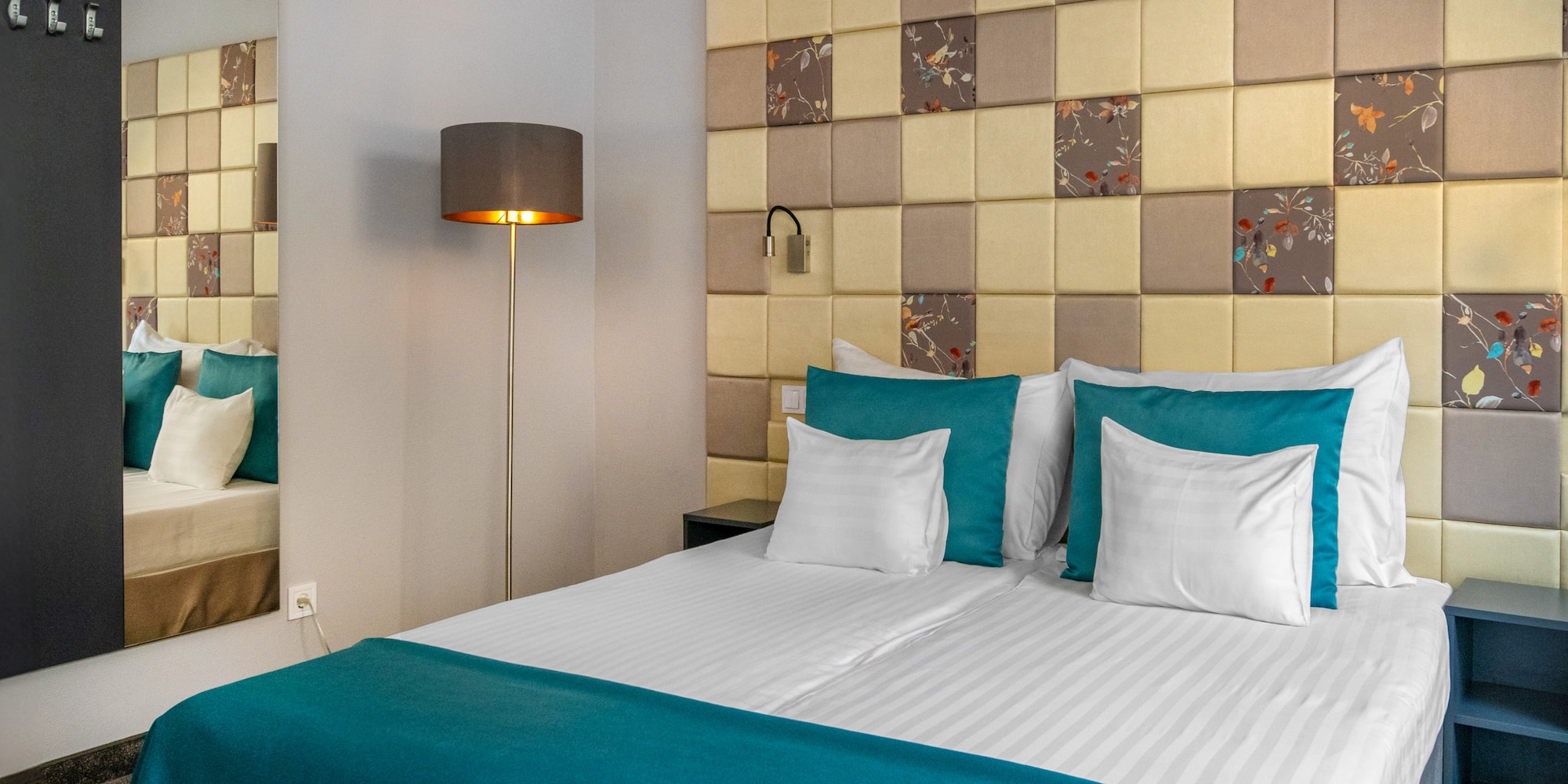 a bed with a lamp and a mirror