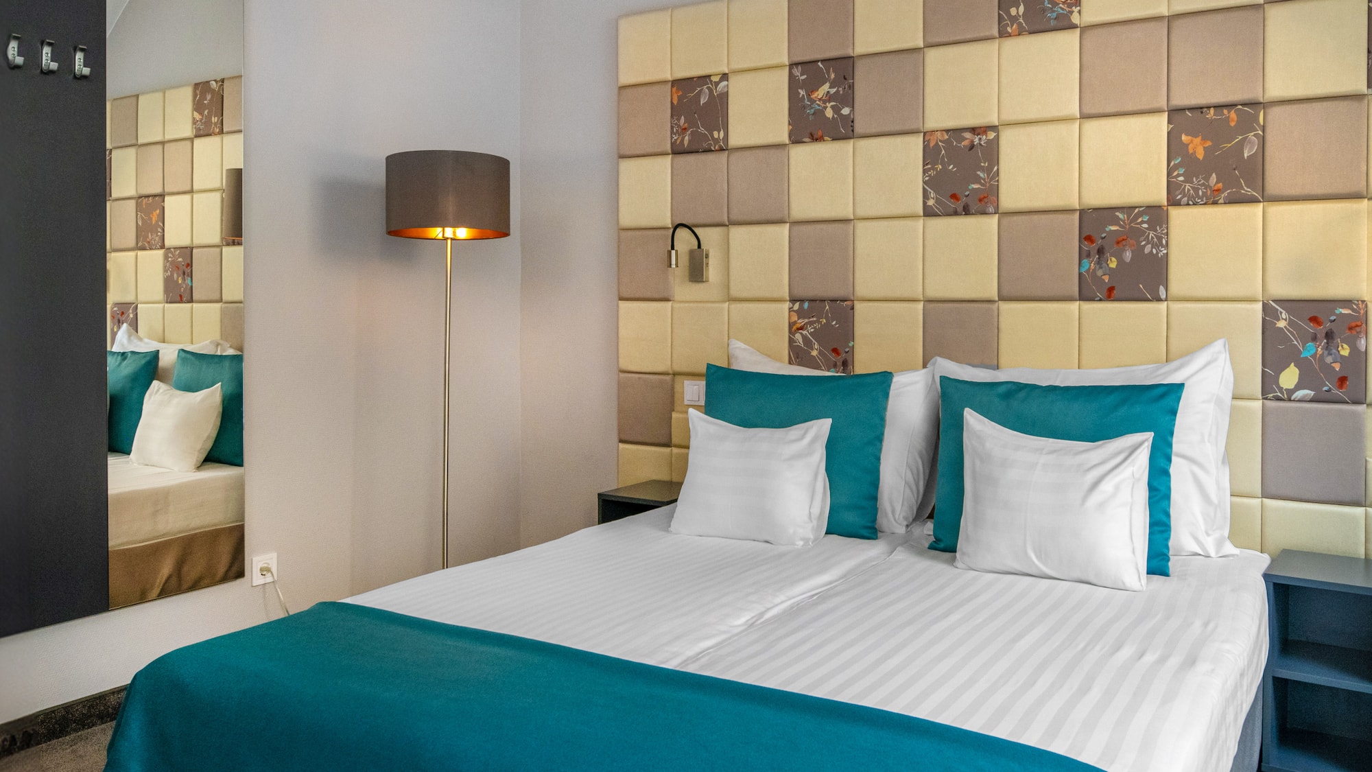 a bed with a lamp and a mirror