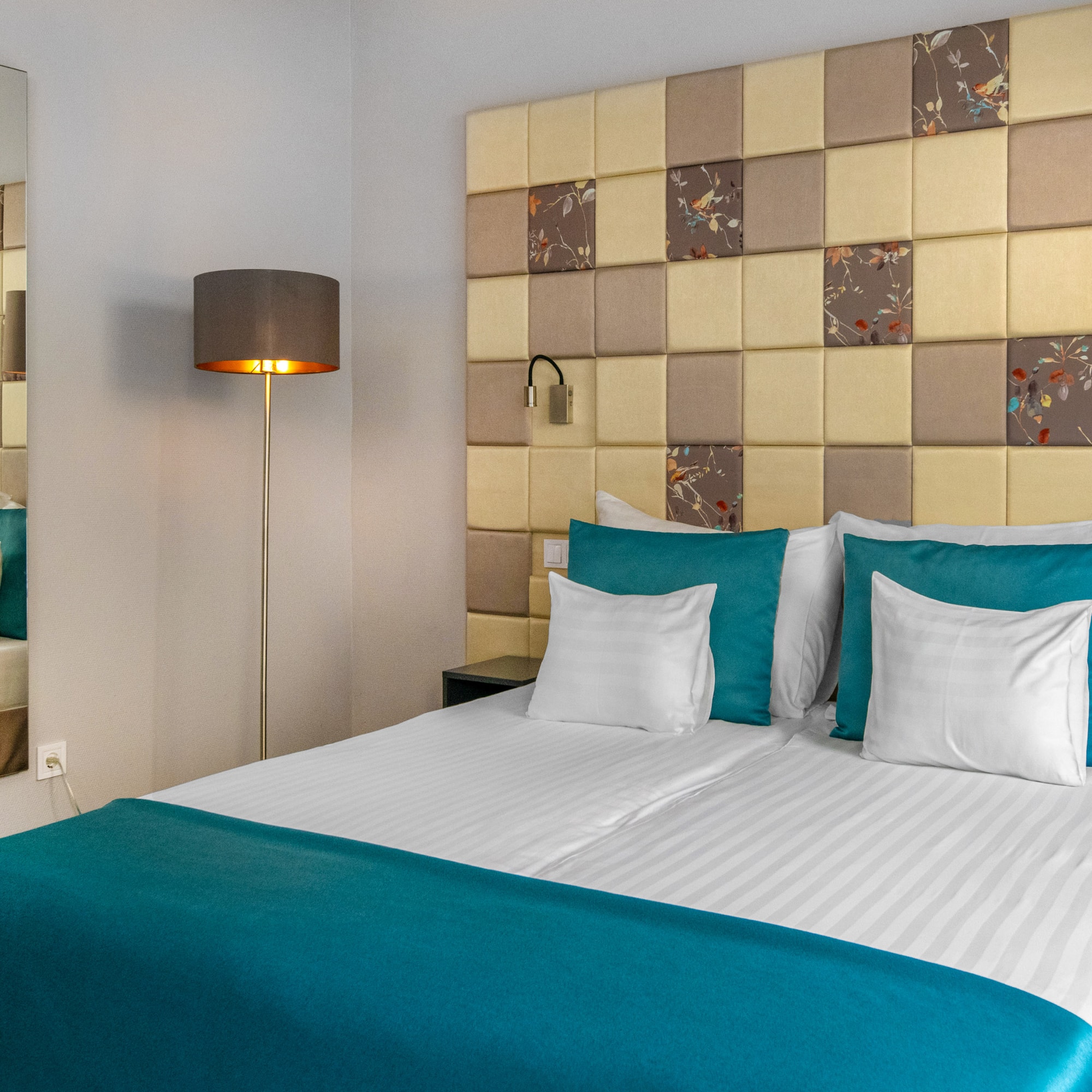 a bed with a lamp and a mirror