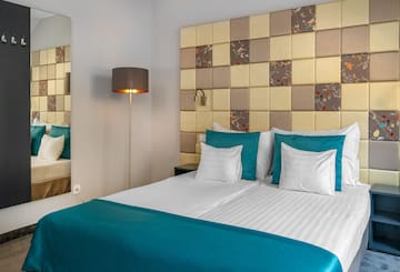 a bed with a lamp and a mirror