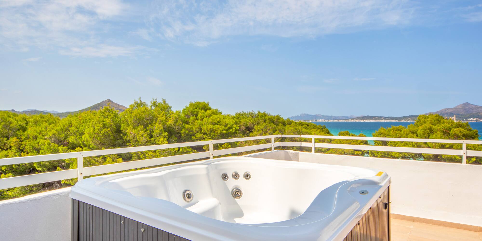 a hot tub on a balcony overlooking a body of water