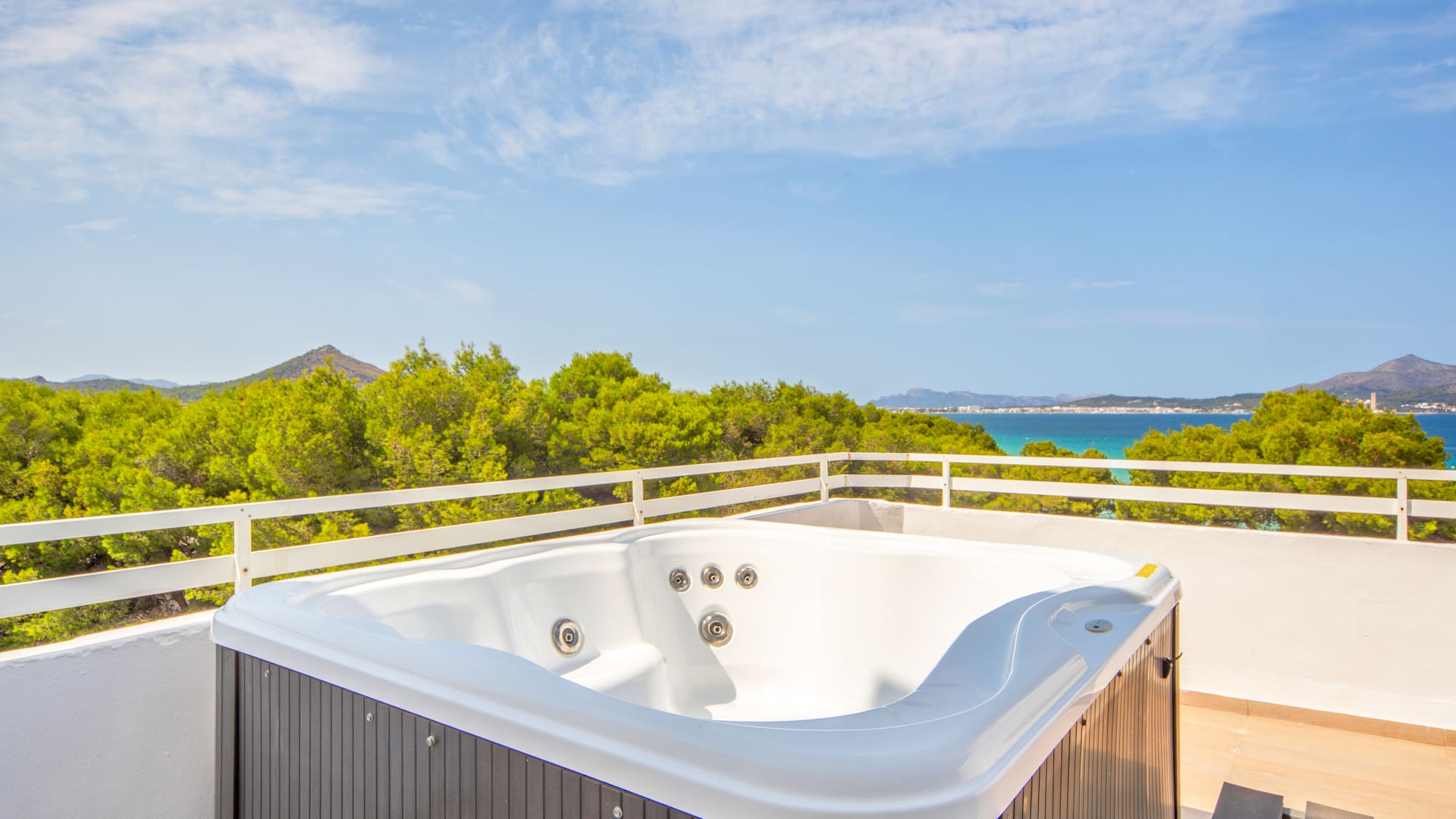 a hot tub on a balcony overlooking a body of water
