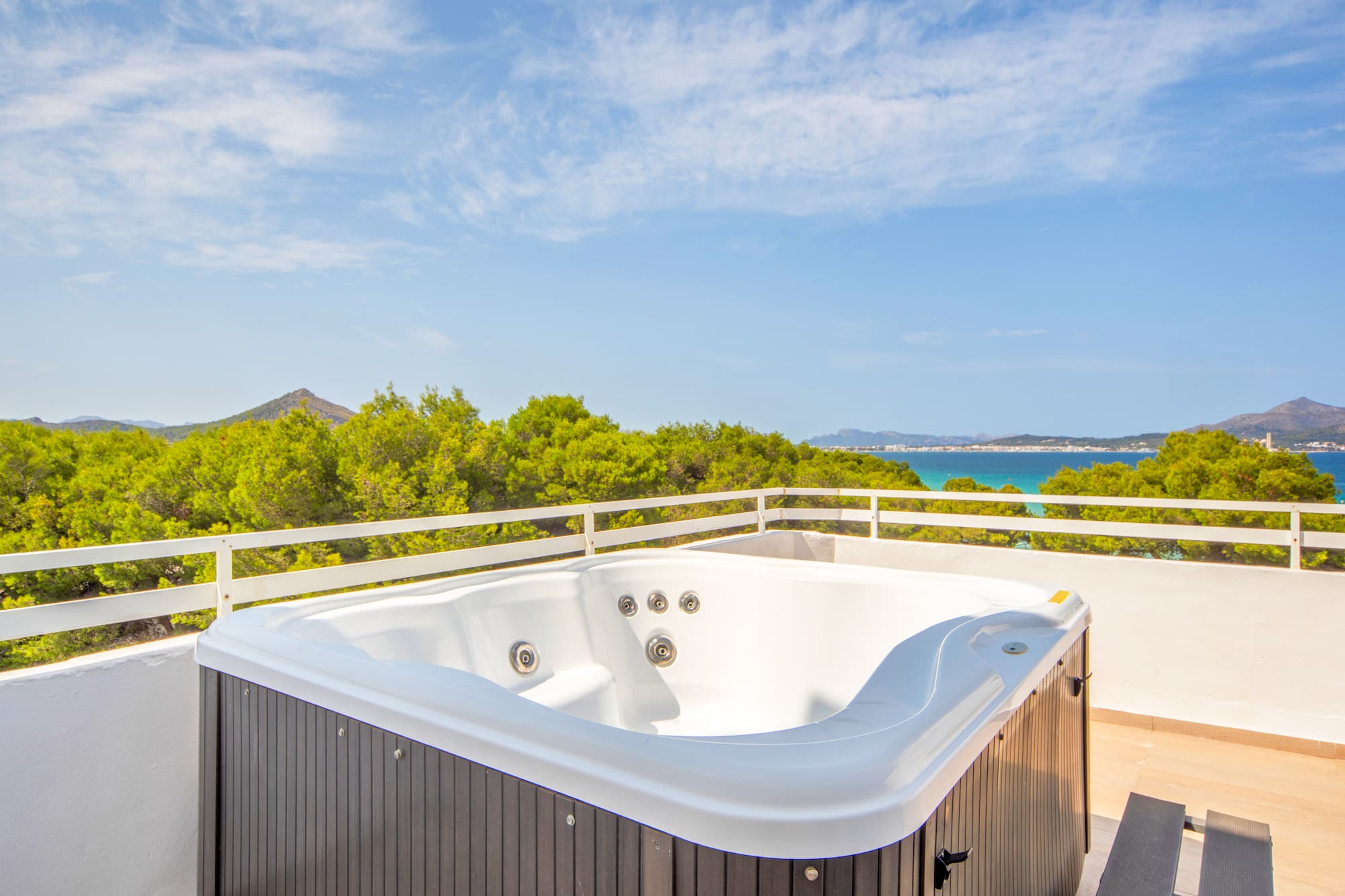a hot tub on a balcony overlooking a body of water