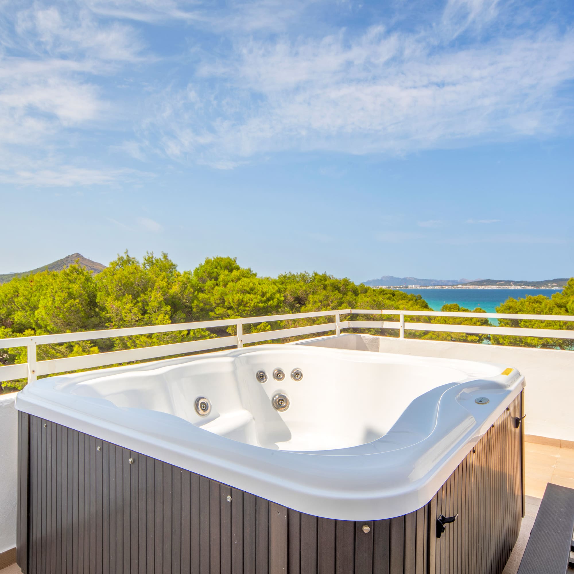 a hot tub on a balcony overlooking a body of water