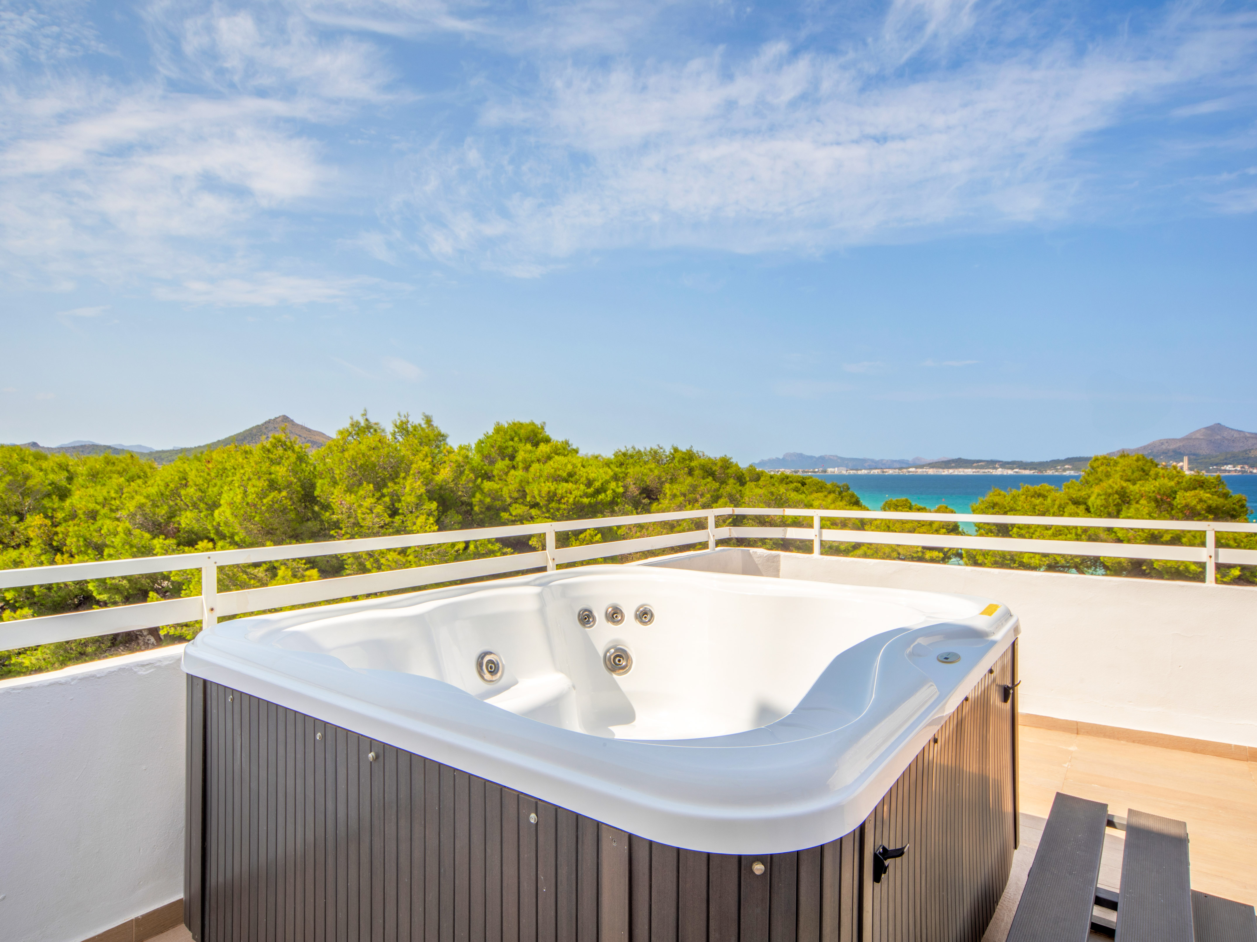 a hot tub on a balcony overlooking a body of water