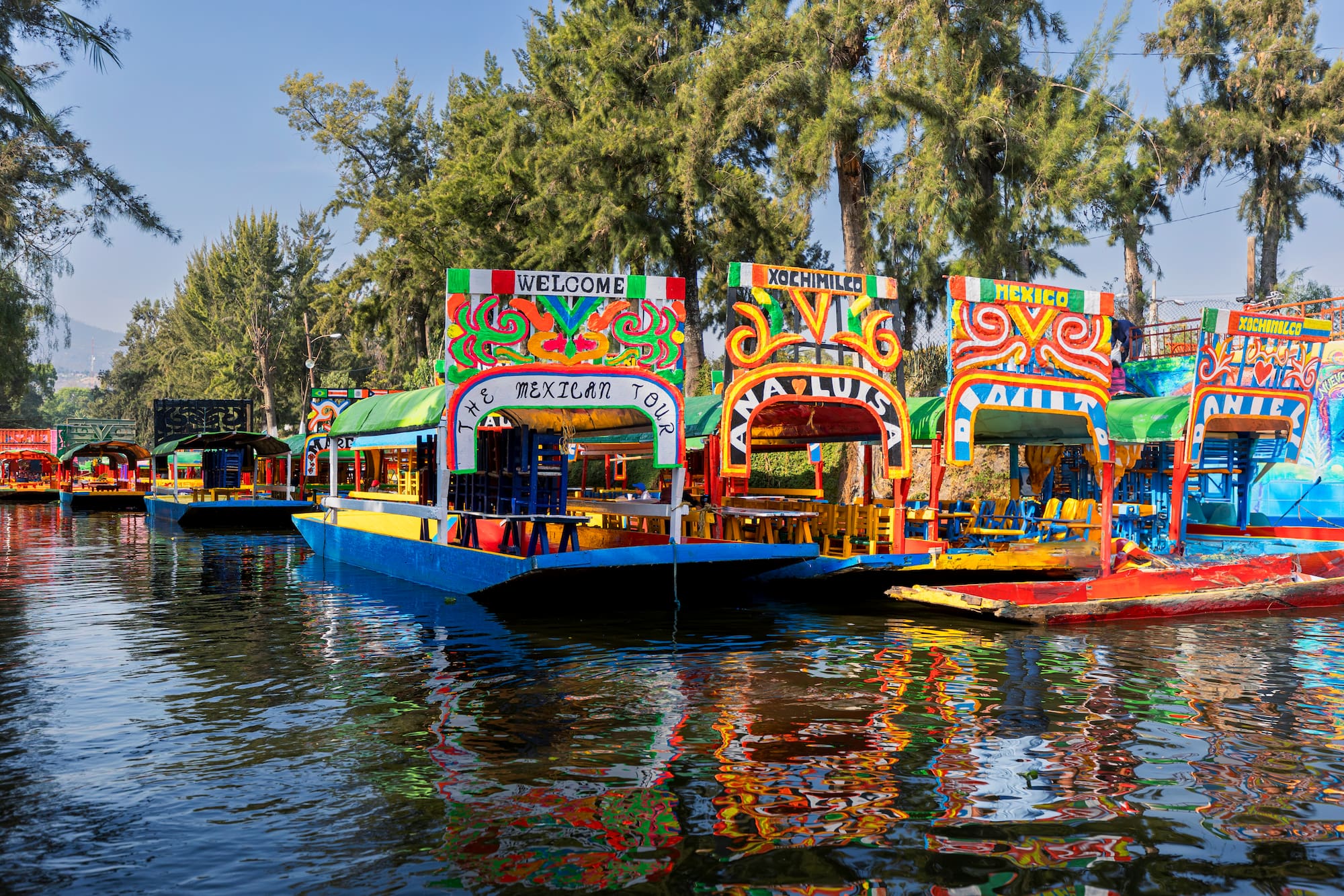 a group of boats on water with Xochimilco in the background