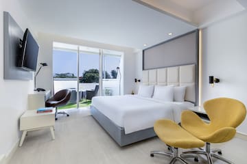 a room with a bed and chairs