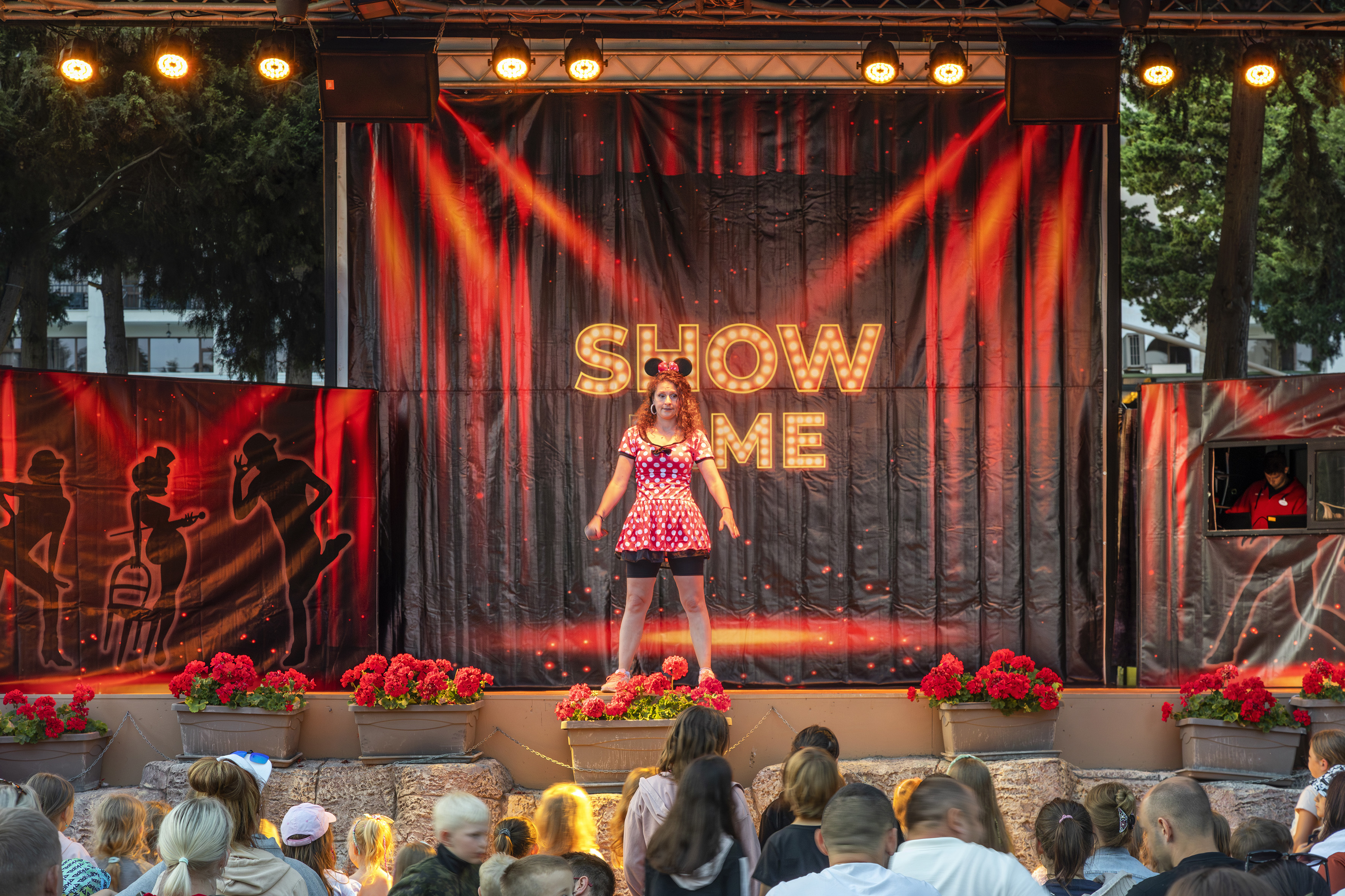 a woman on stage with a crowd of people watching