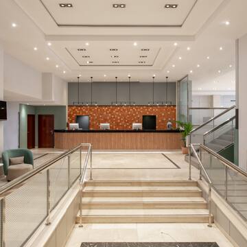 a lobby with a reception desk and stairs