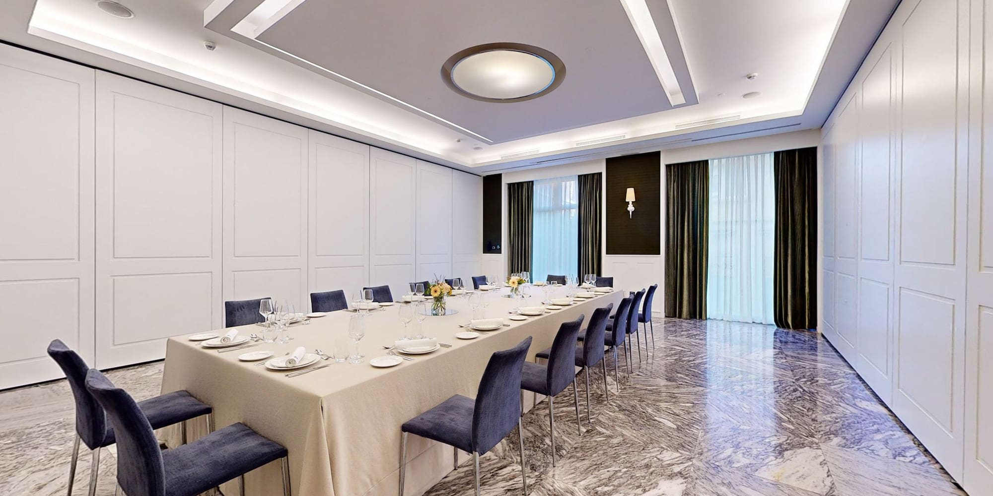 a long table with blue chairs and a white tablecloth