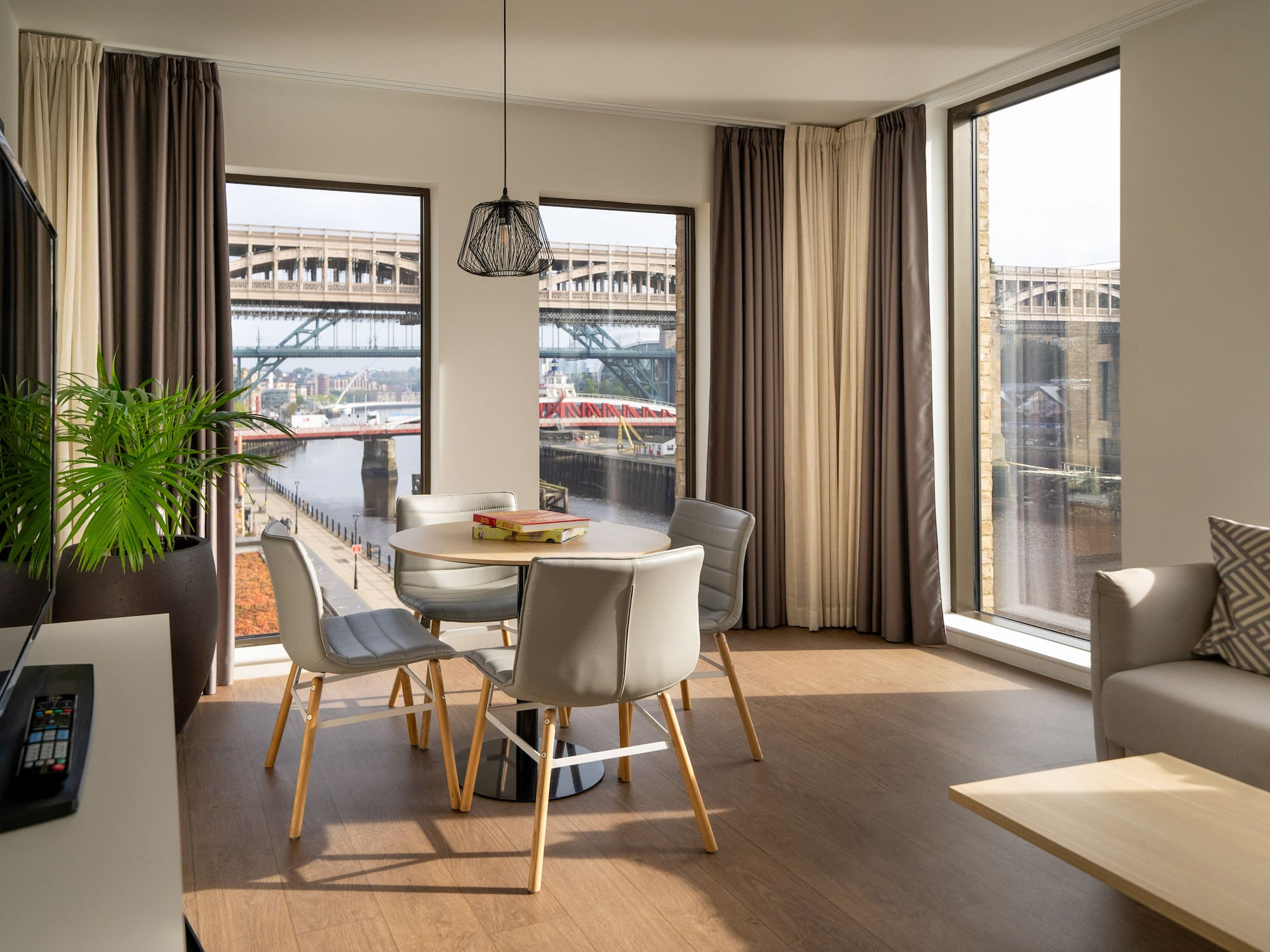 Modern apartment dining area with River Tyne bridges view.