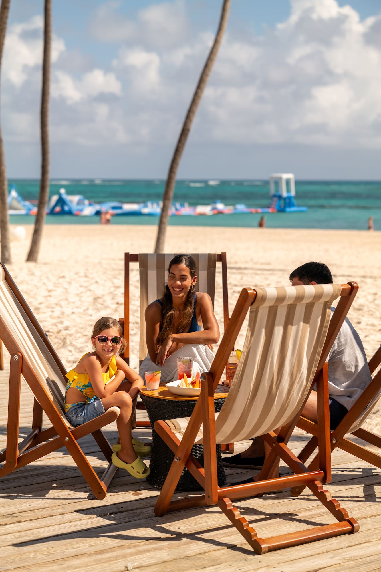 a group of people sitting at a table on a beach