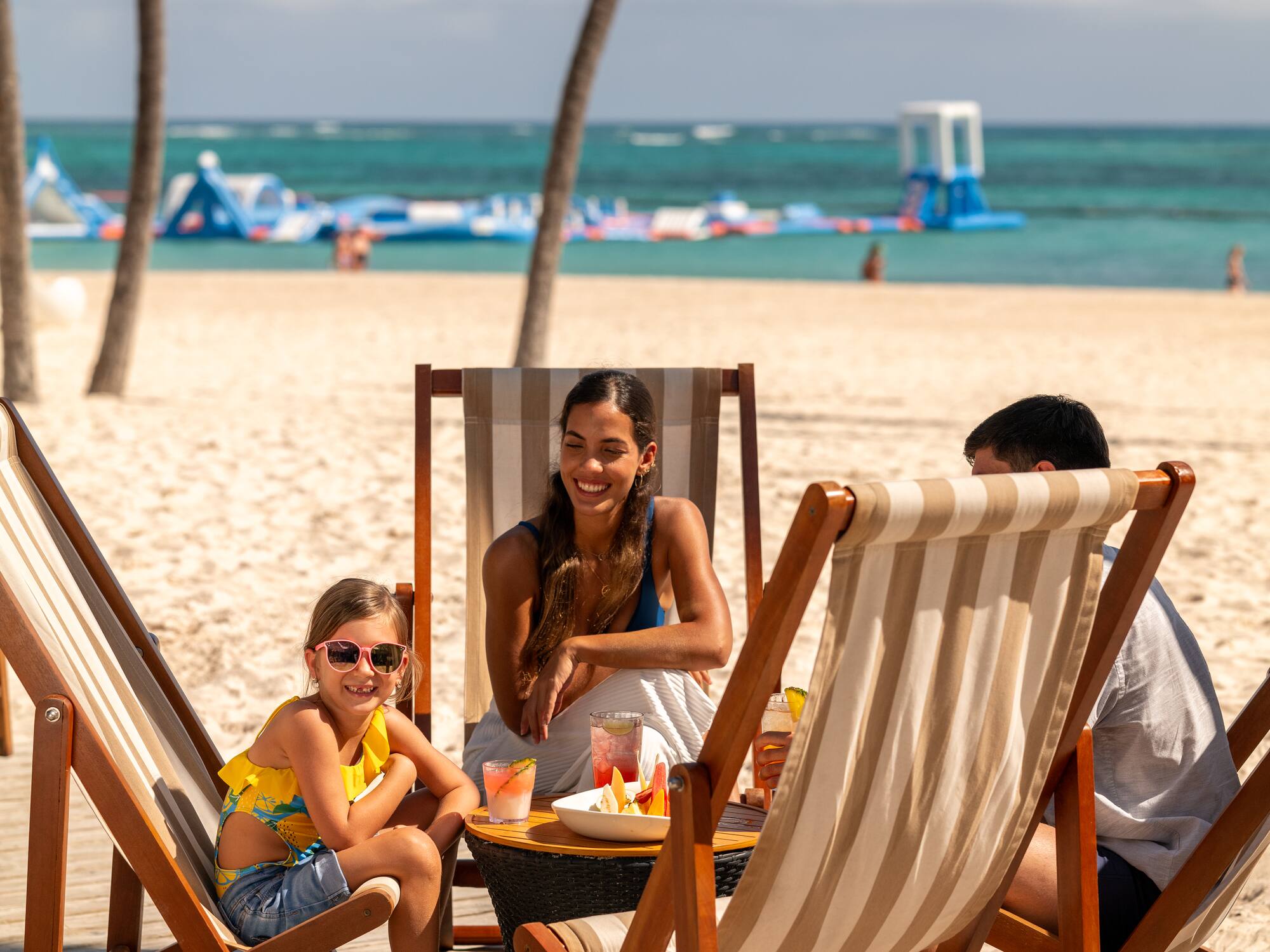 a group of people sitting at a table on a beach