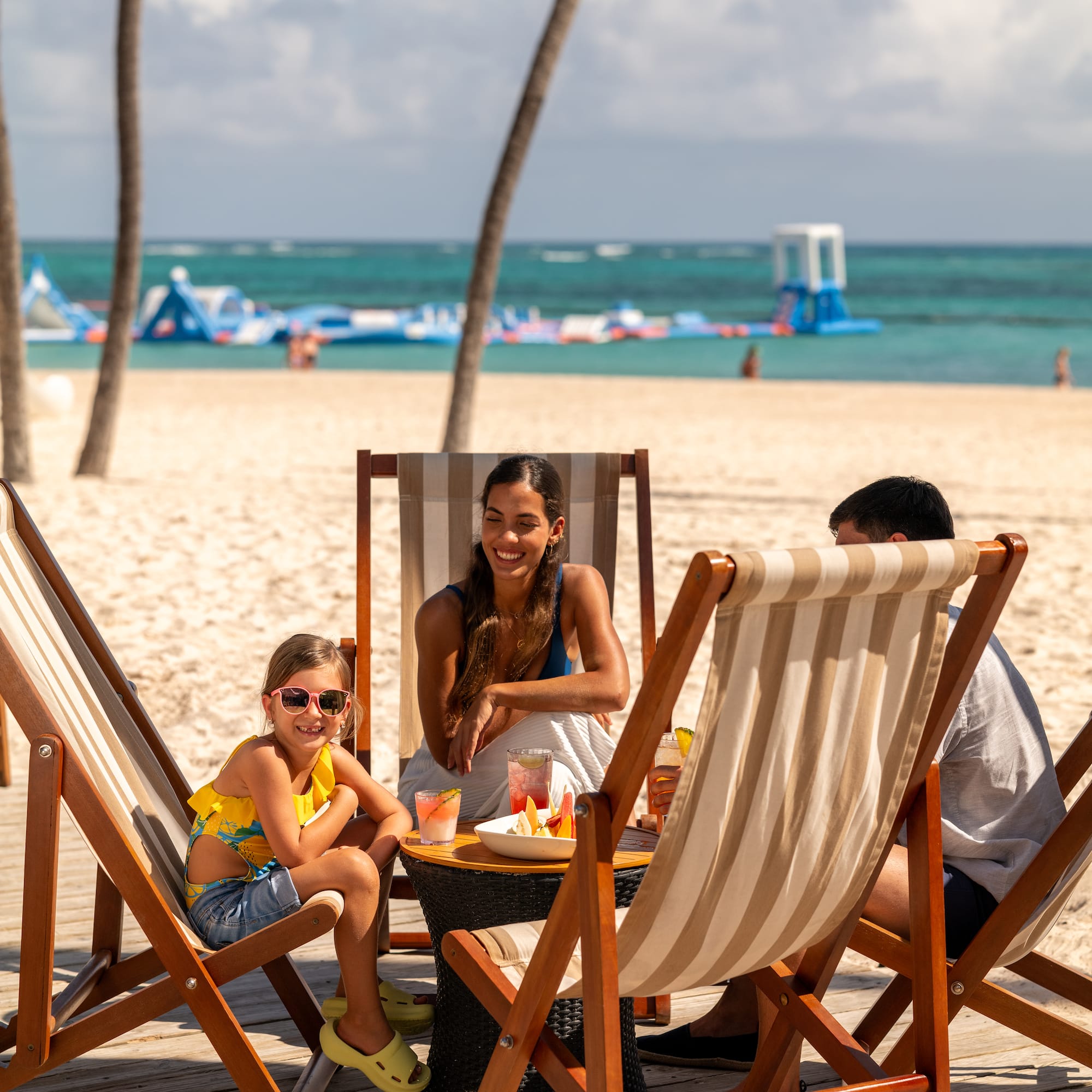a group of people sitting at a table on a beach