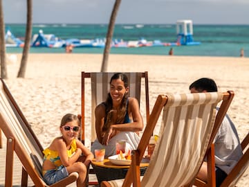 a group of people sitting at a table on a beach