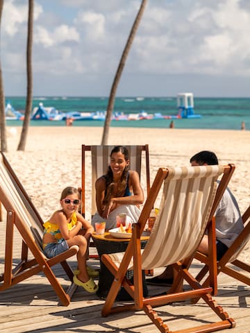 a group of people sitting at a table on a beach