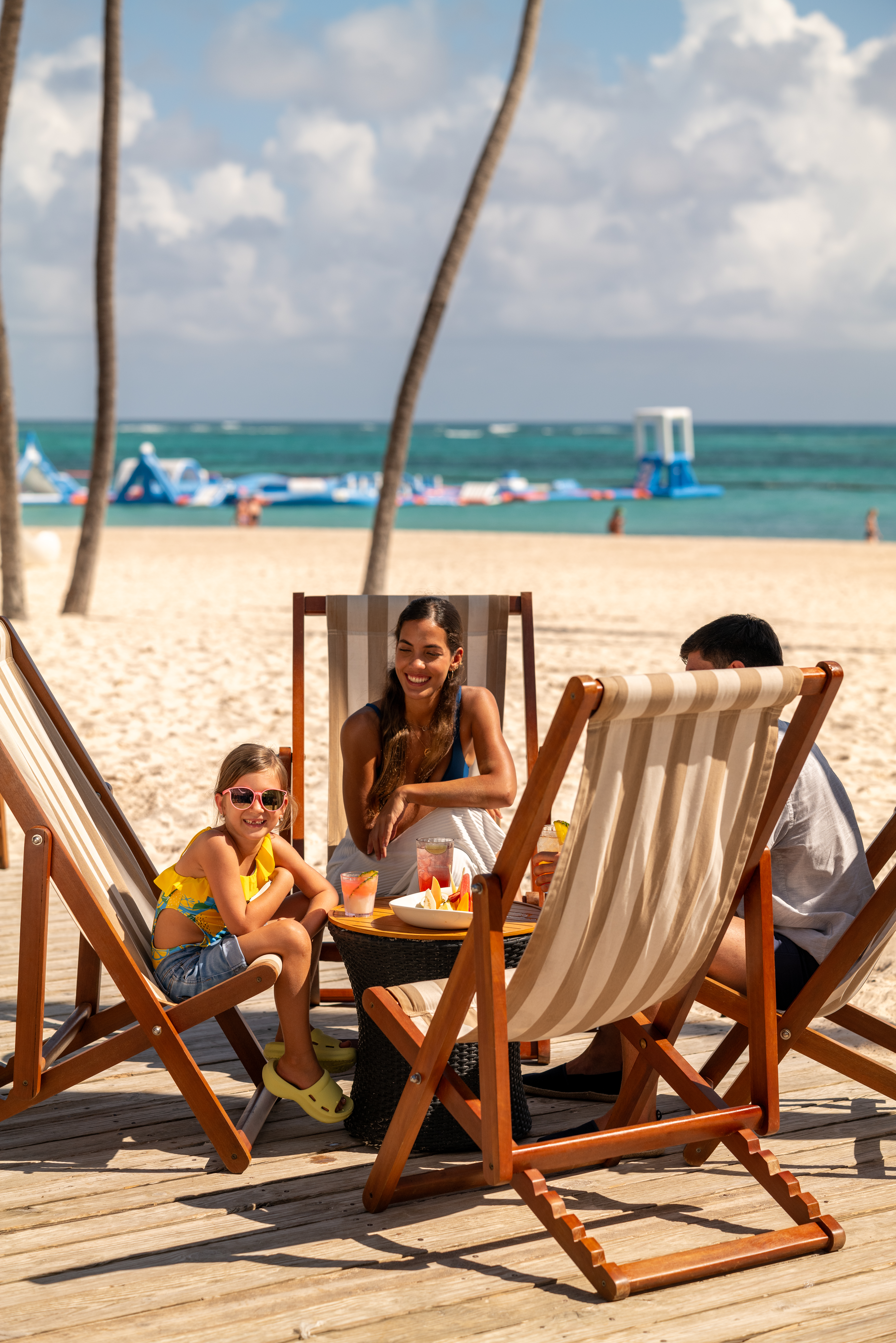 a group of people sitting at a table on a beach