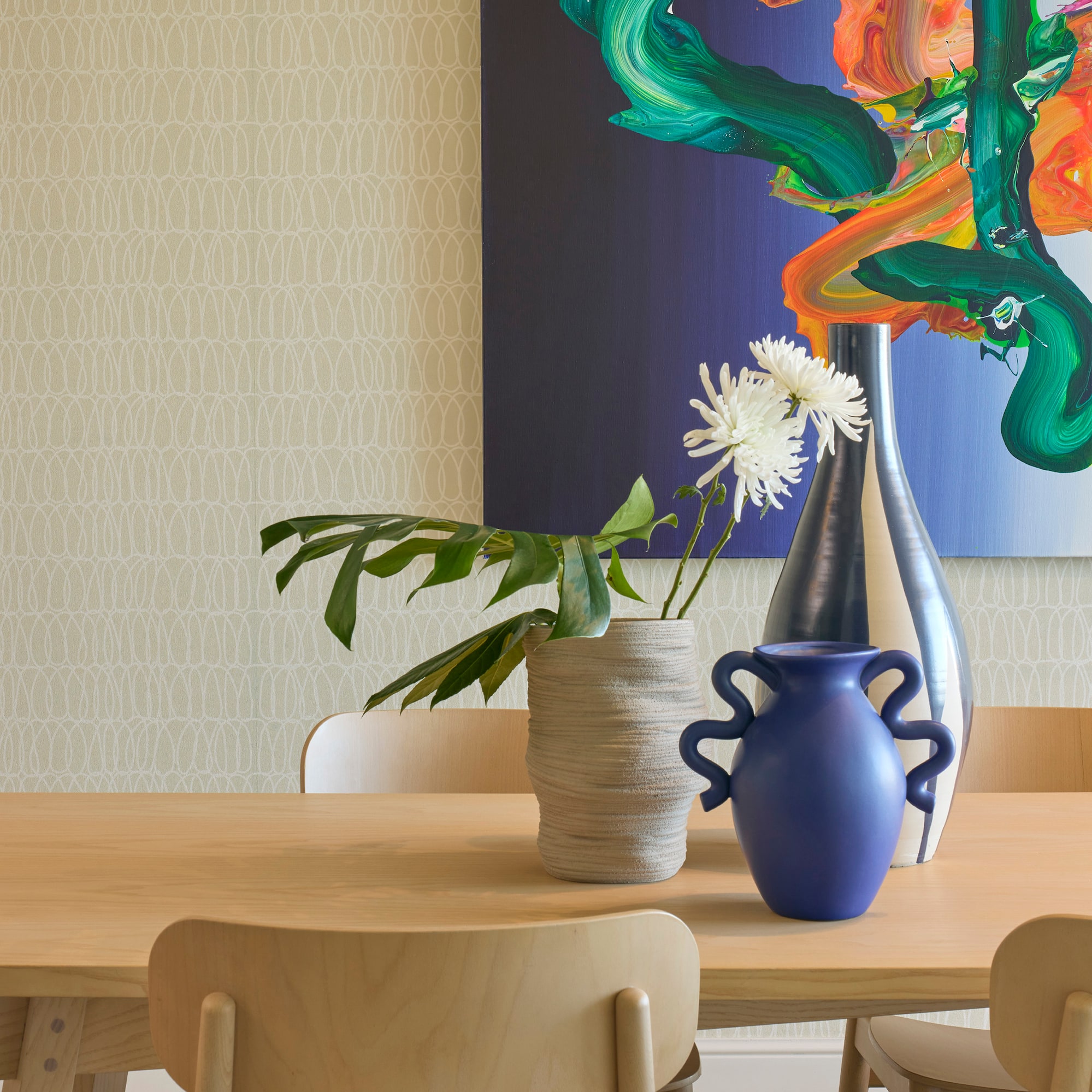 a table with chairs and vases on it