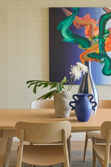 a table with chairs and vases on it