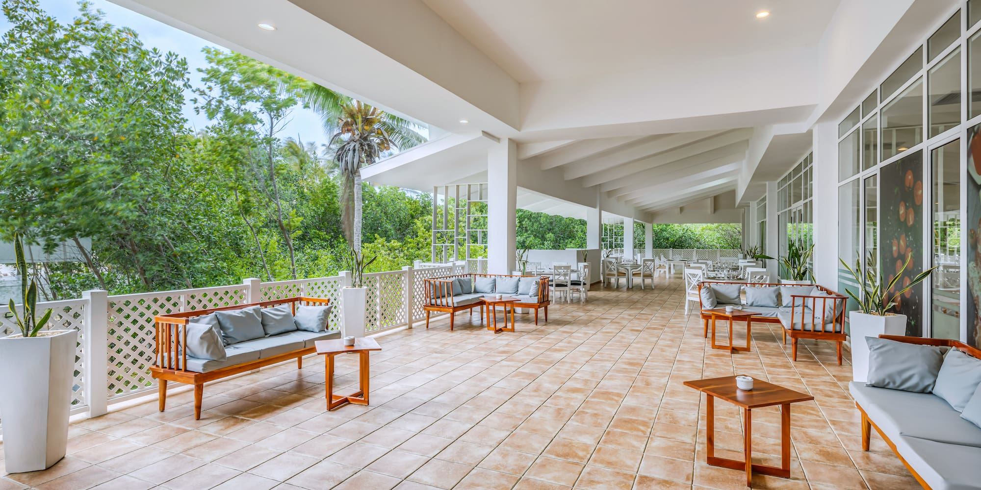 a patio with a white railing and chairs and tables