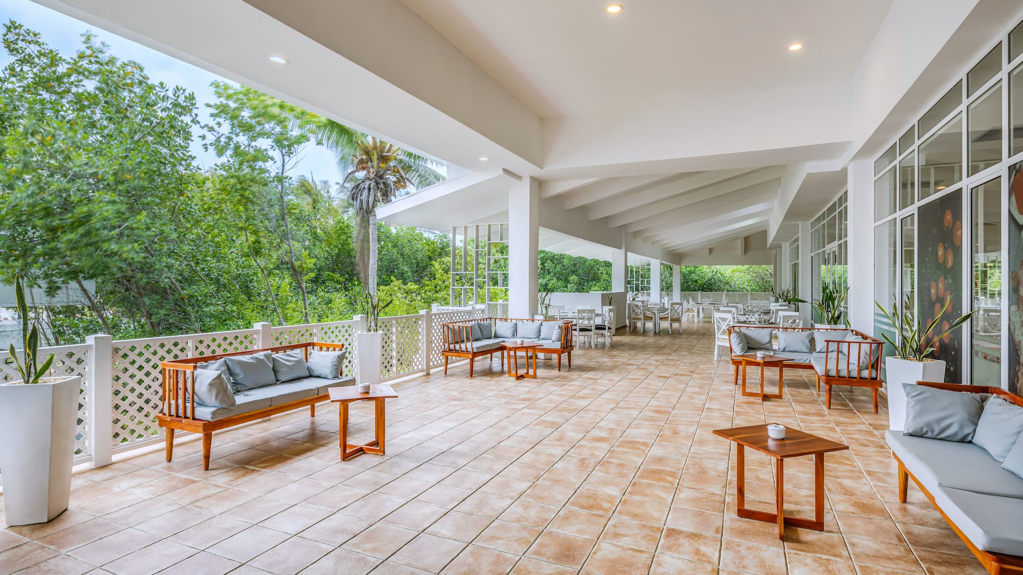 a patio with a white railing and chairs and tables