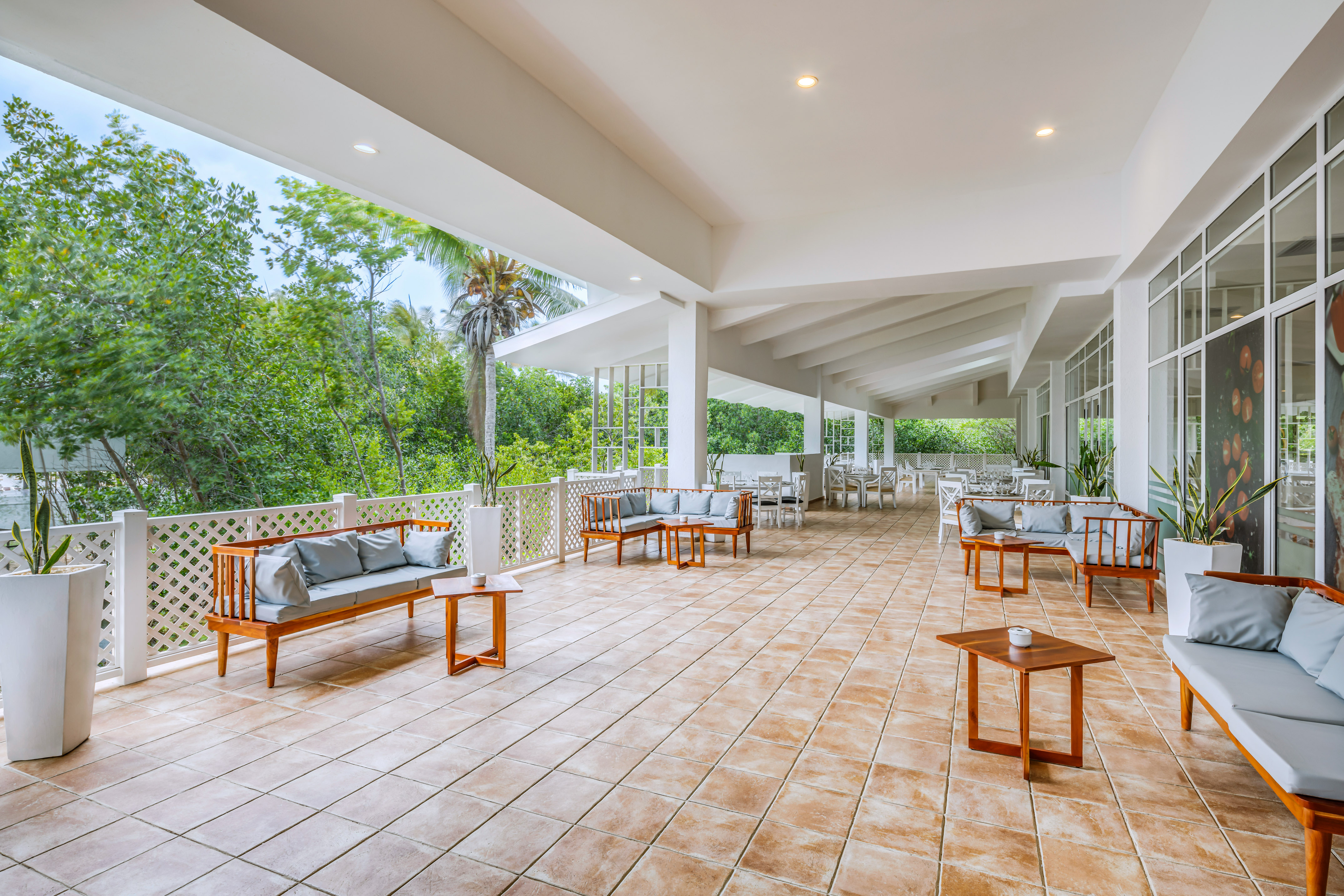 a patio with a white railing and chairs and tables