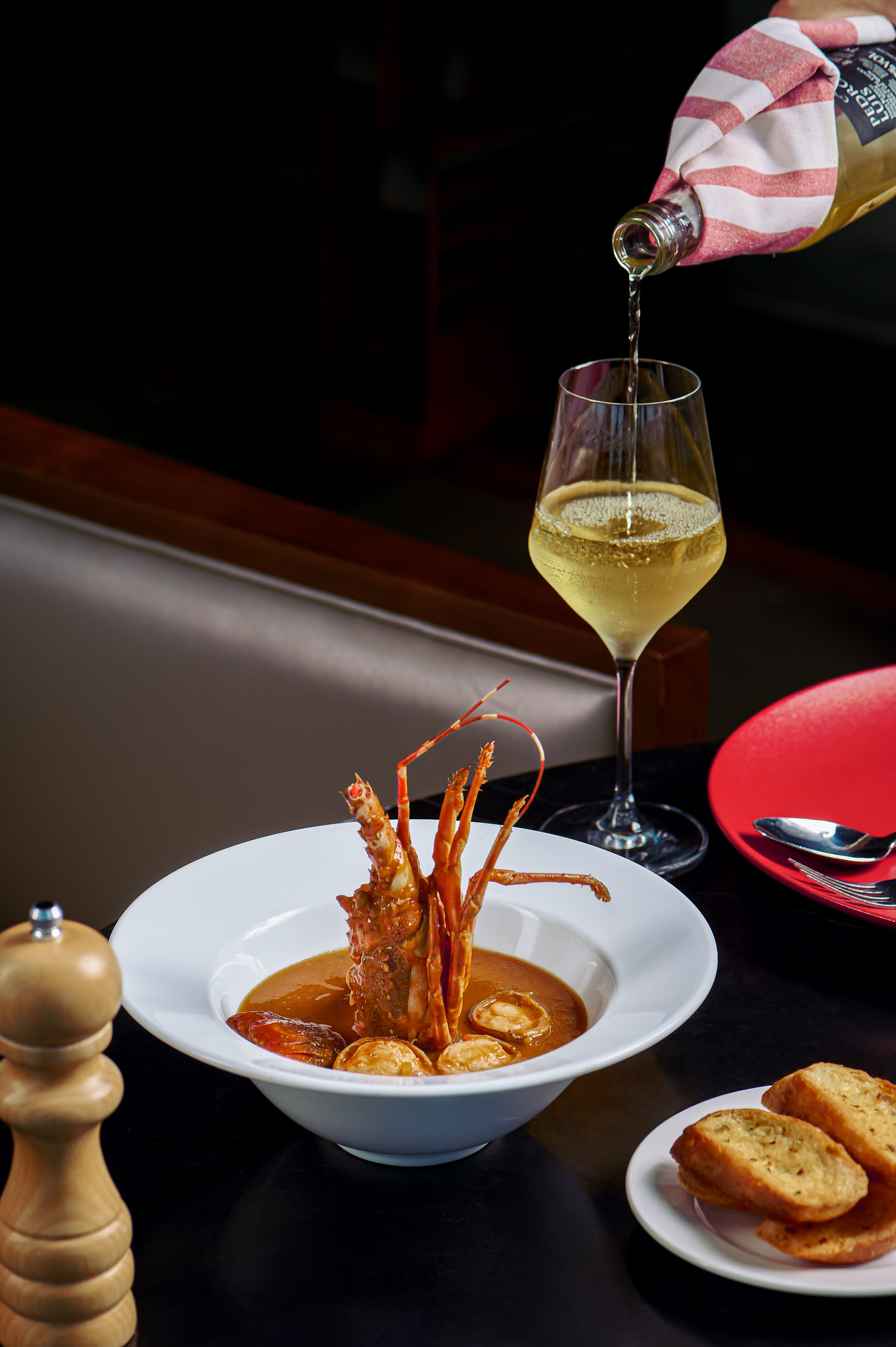 Gourmet lobster and scallop stew, white wine pour, toasted bread.