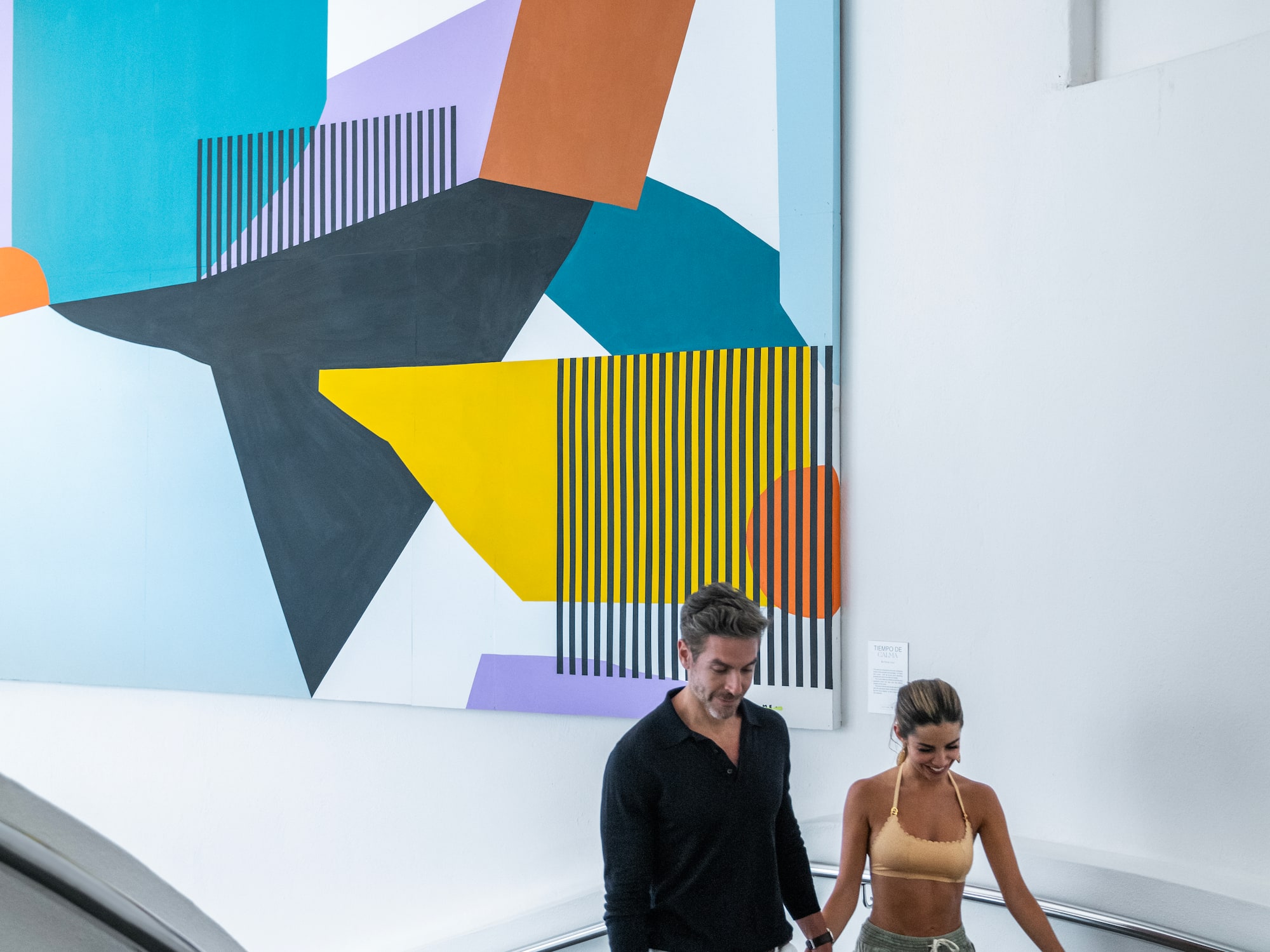 a man and woman walking down a staircase