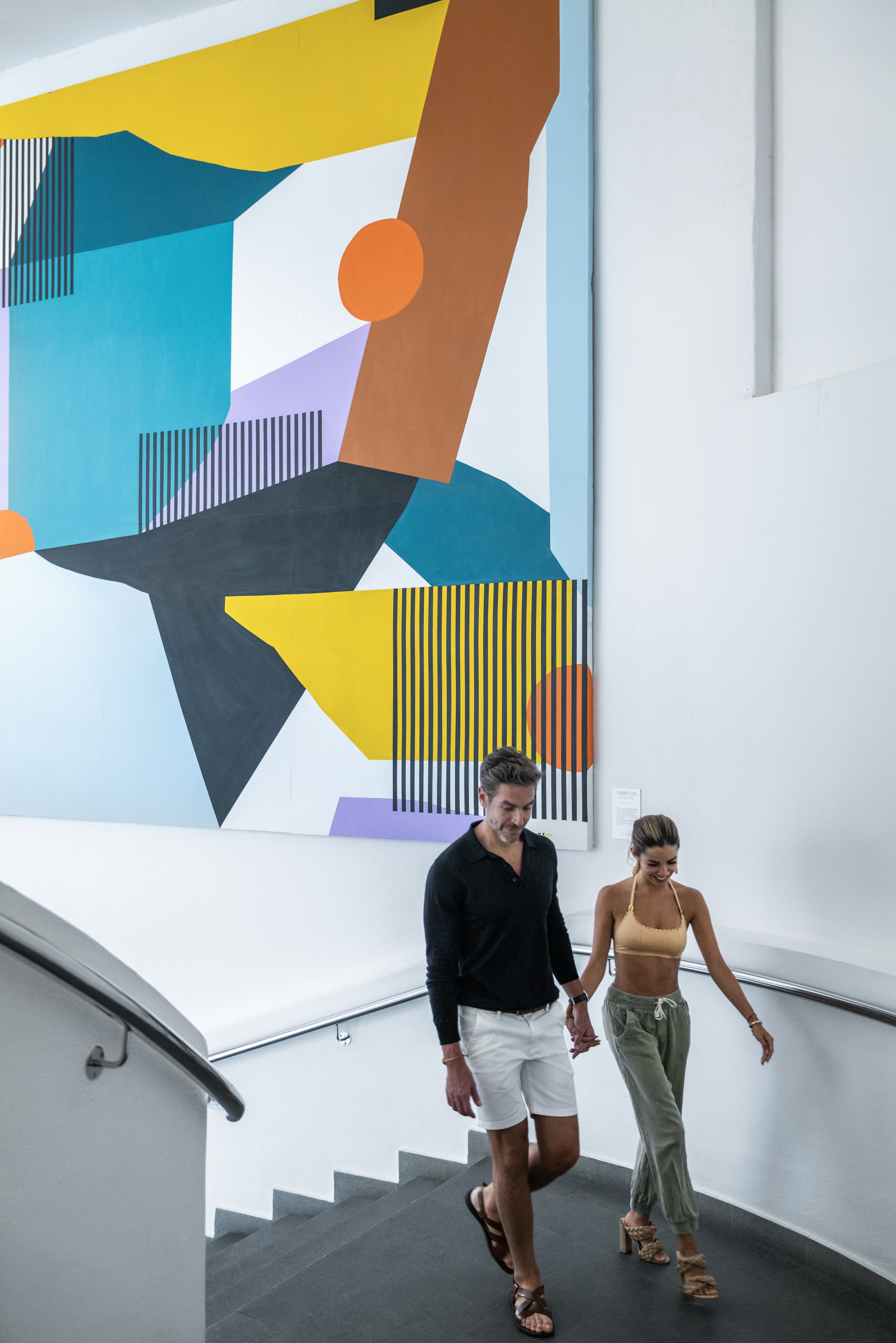 a man and woman walking down a staircase