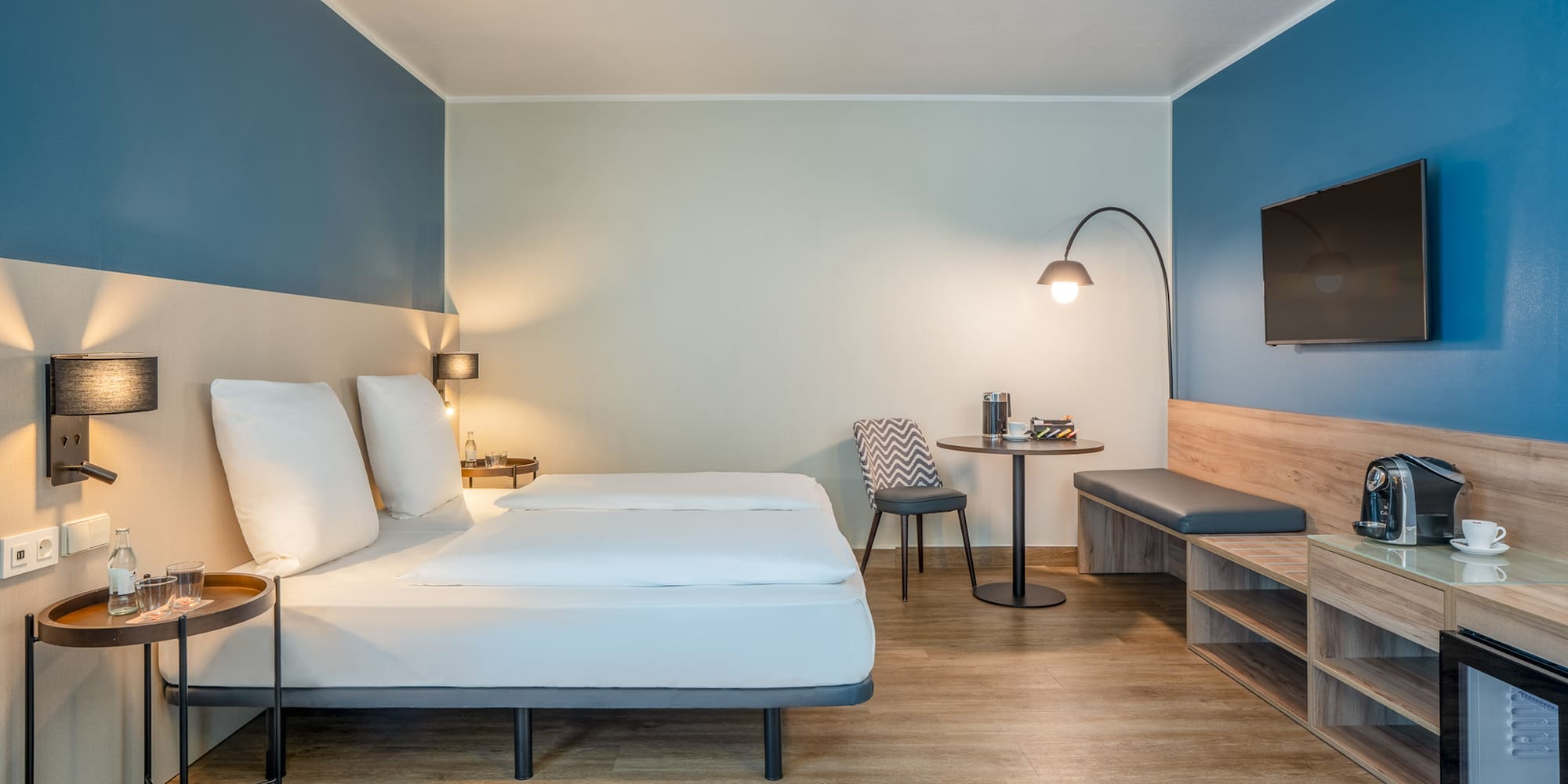 a room with a bed and a table and a tv