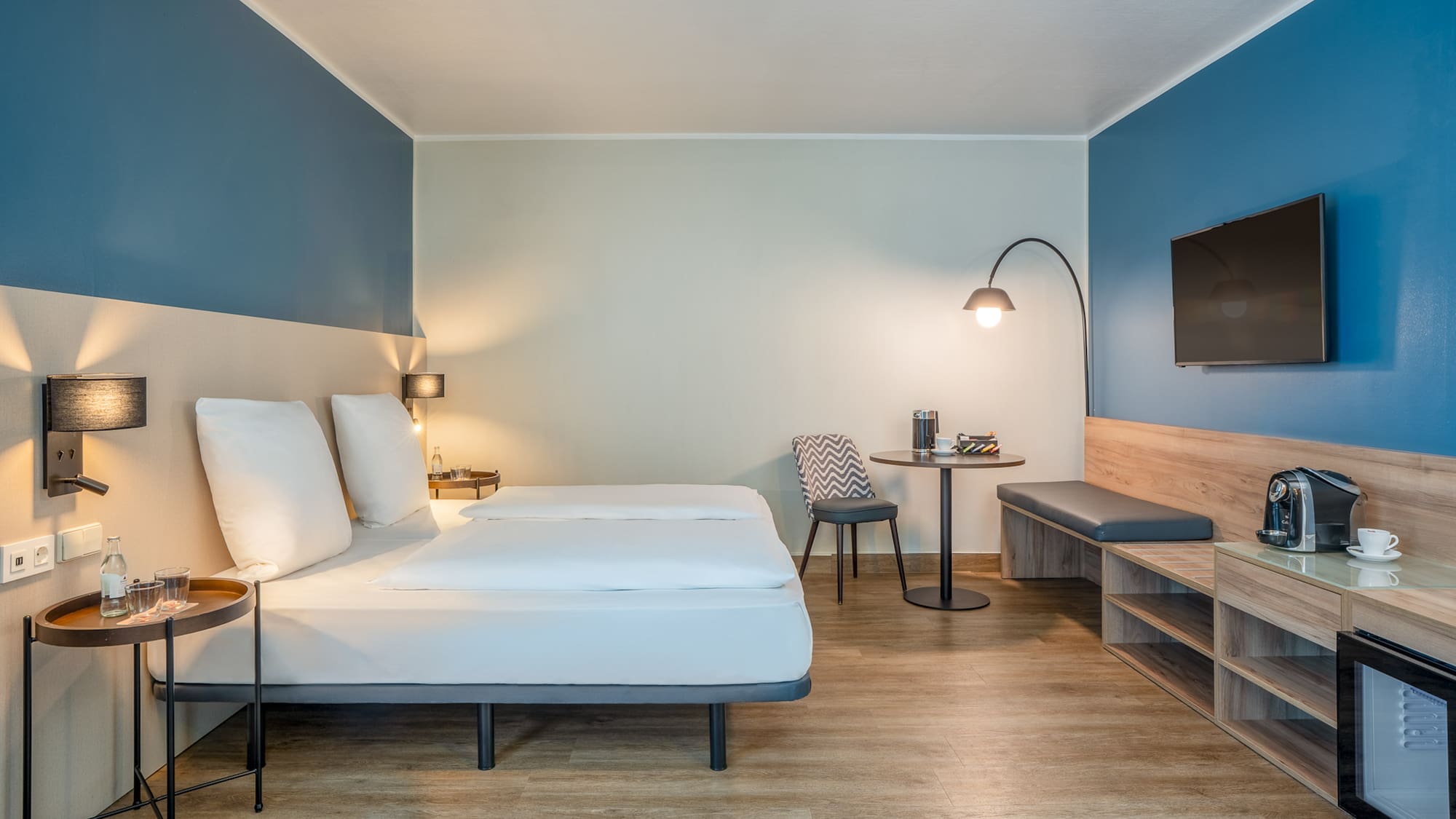 a room with a bed and a table and a tv