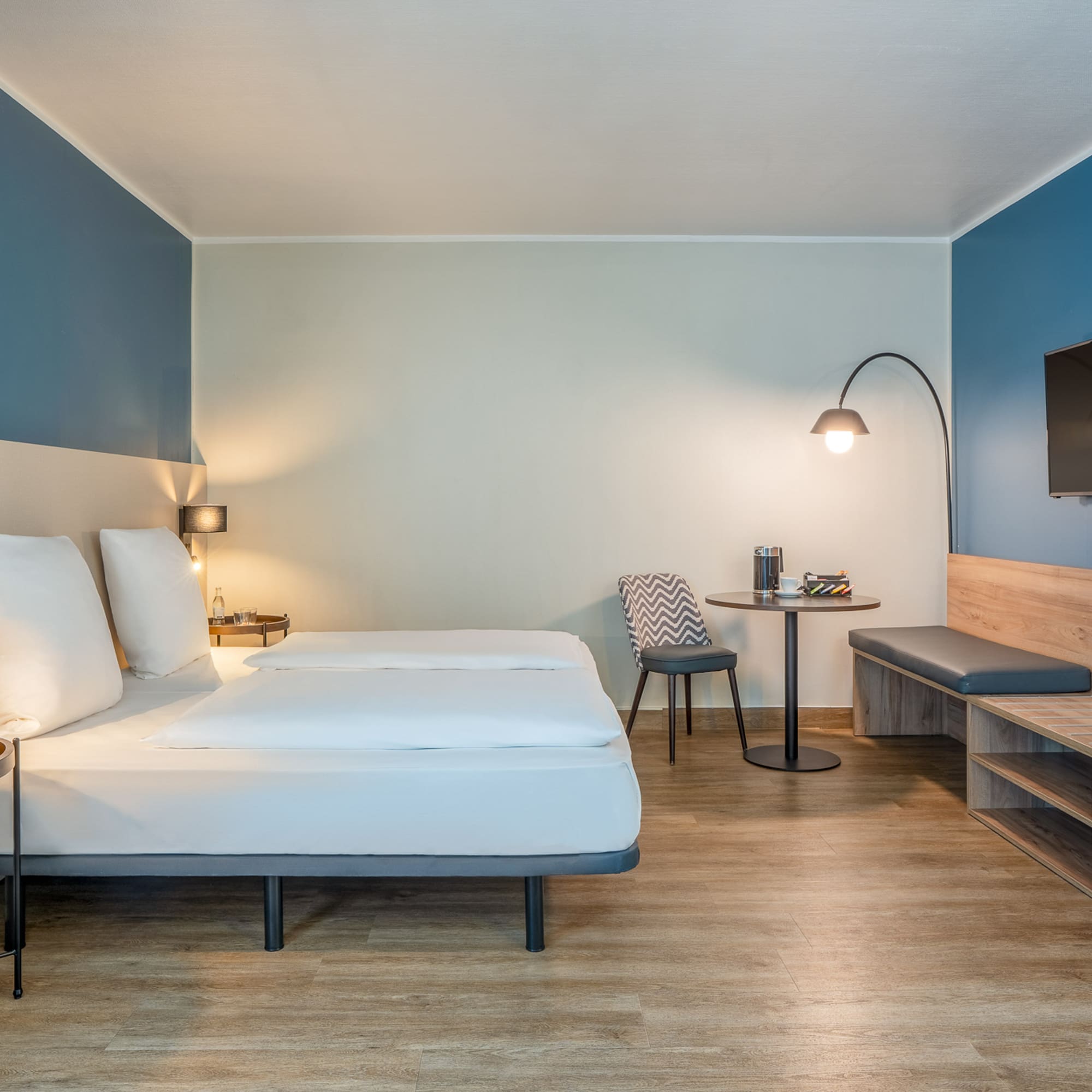 a room with a bed and a table and a tv