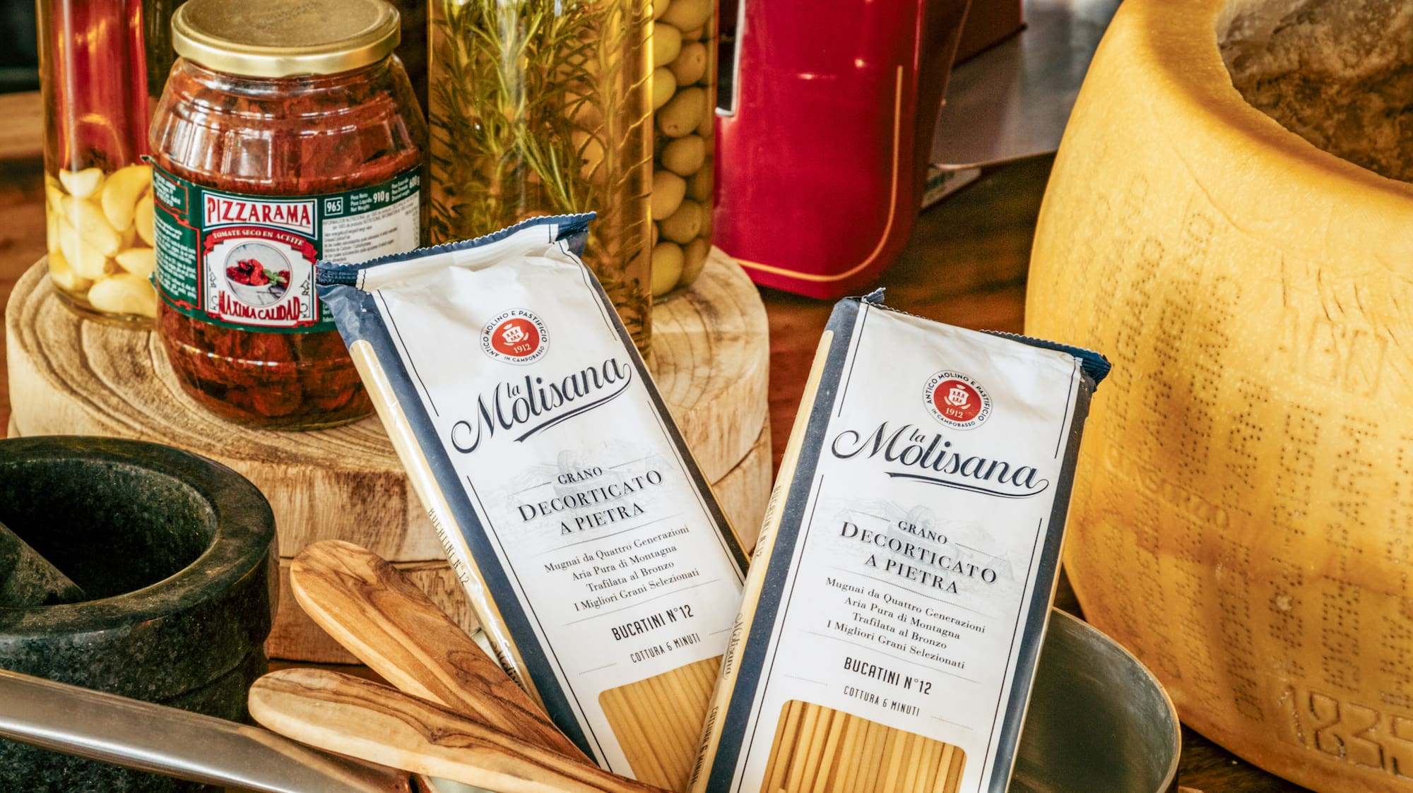 a copper pan with food in it and bottles of spices on a wooden surface