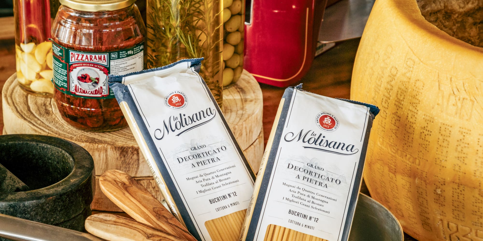 a copper pan with food in it and bottles of spices on a wooden surface