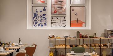 a room with a table and chairs and art on the wall