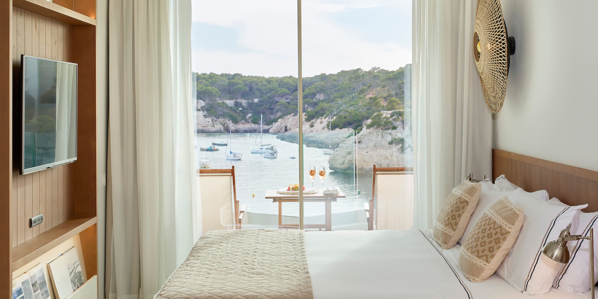 a room with a bed and a view of the water