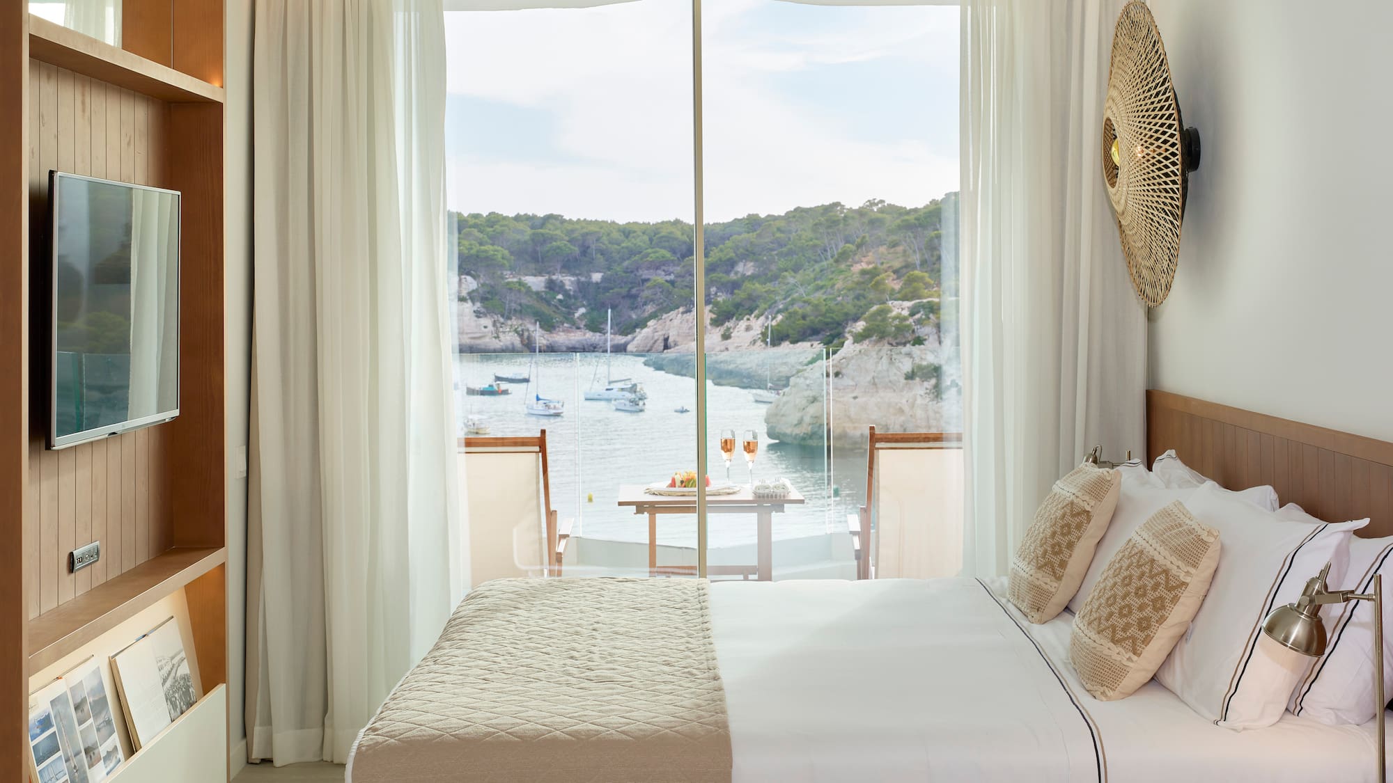 a room with a bed and a view of the water