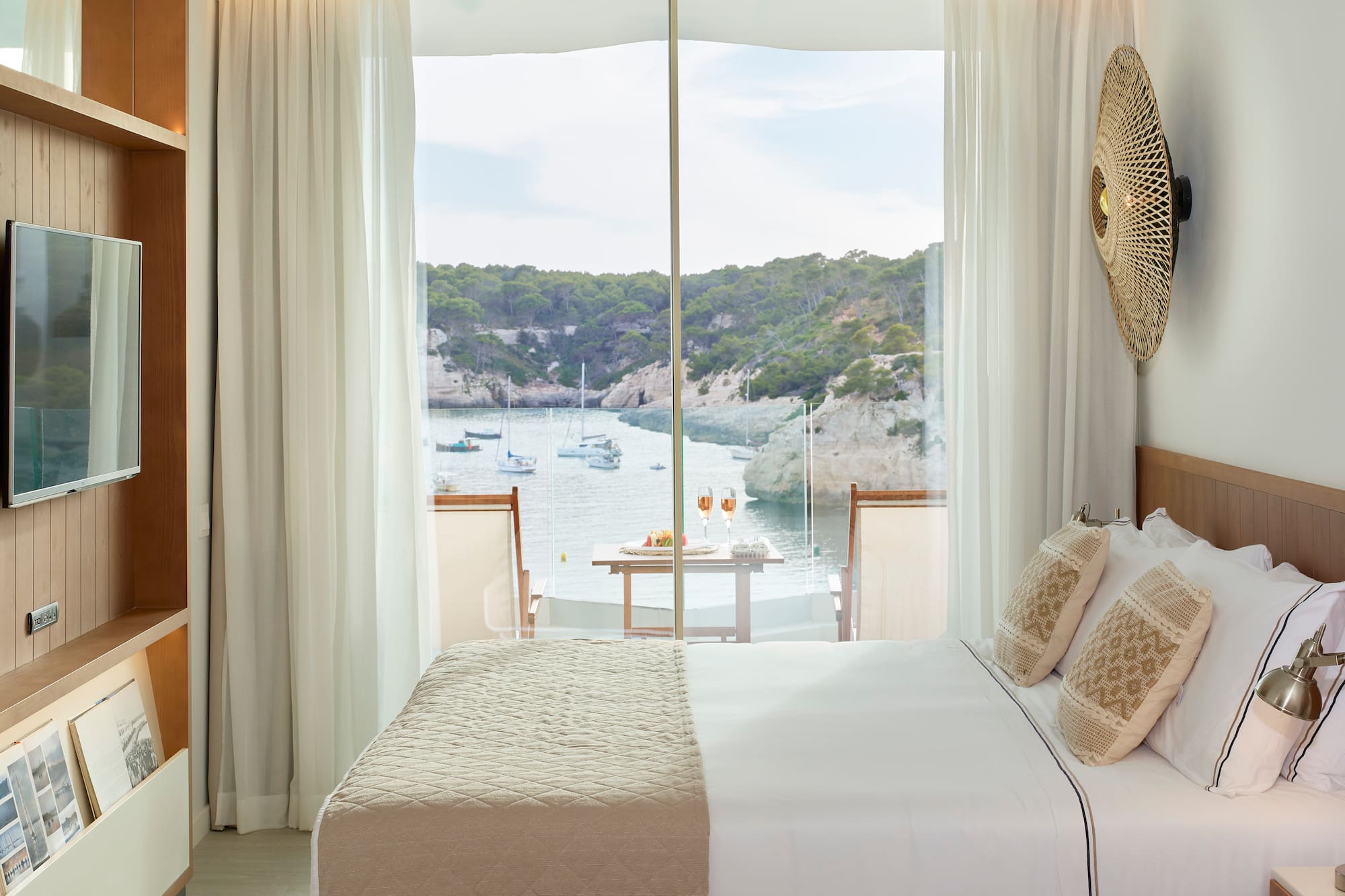 a room with a bed and a view of the water