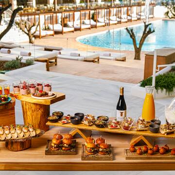 a table with food on it and a pool in the background