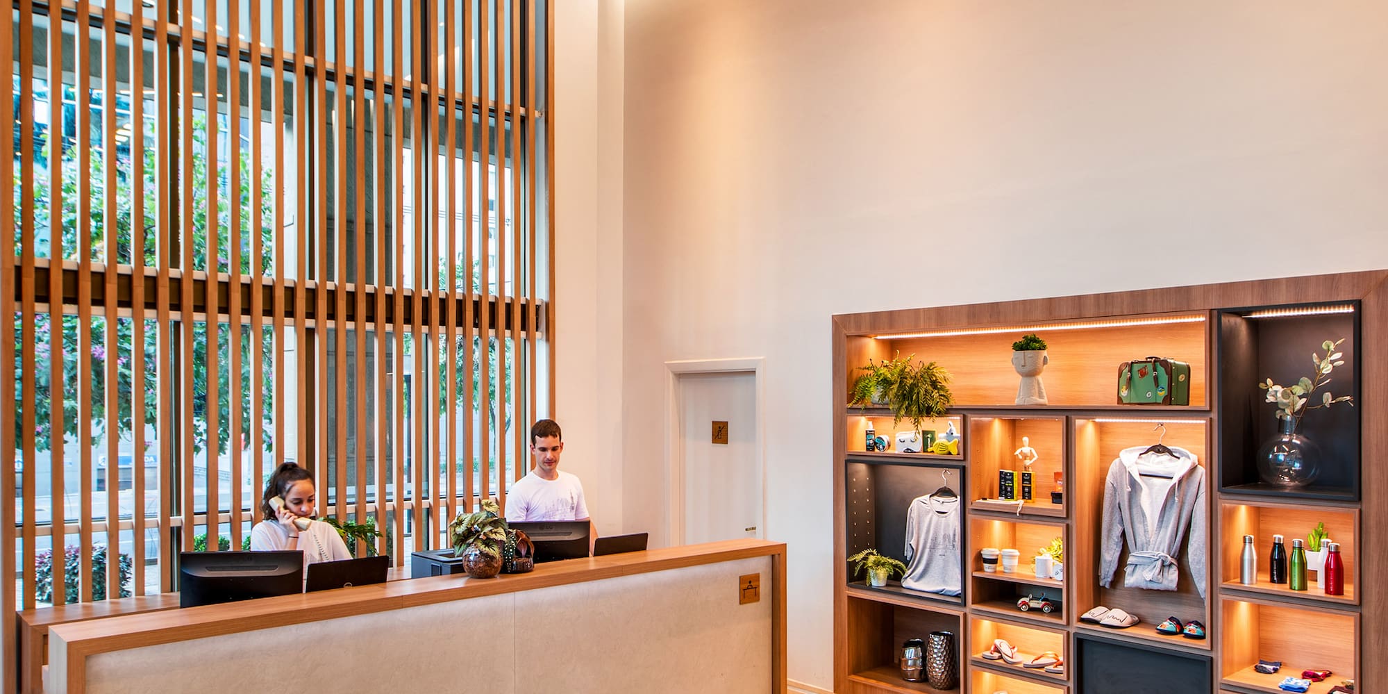 a man and woman standing at a reception desk in a hotel