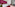 Hotel room with red velvet bed, magenta wall, and patterned red carpet.